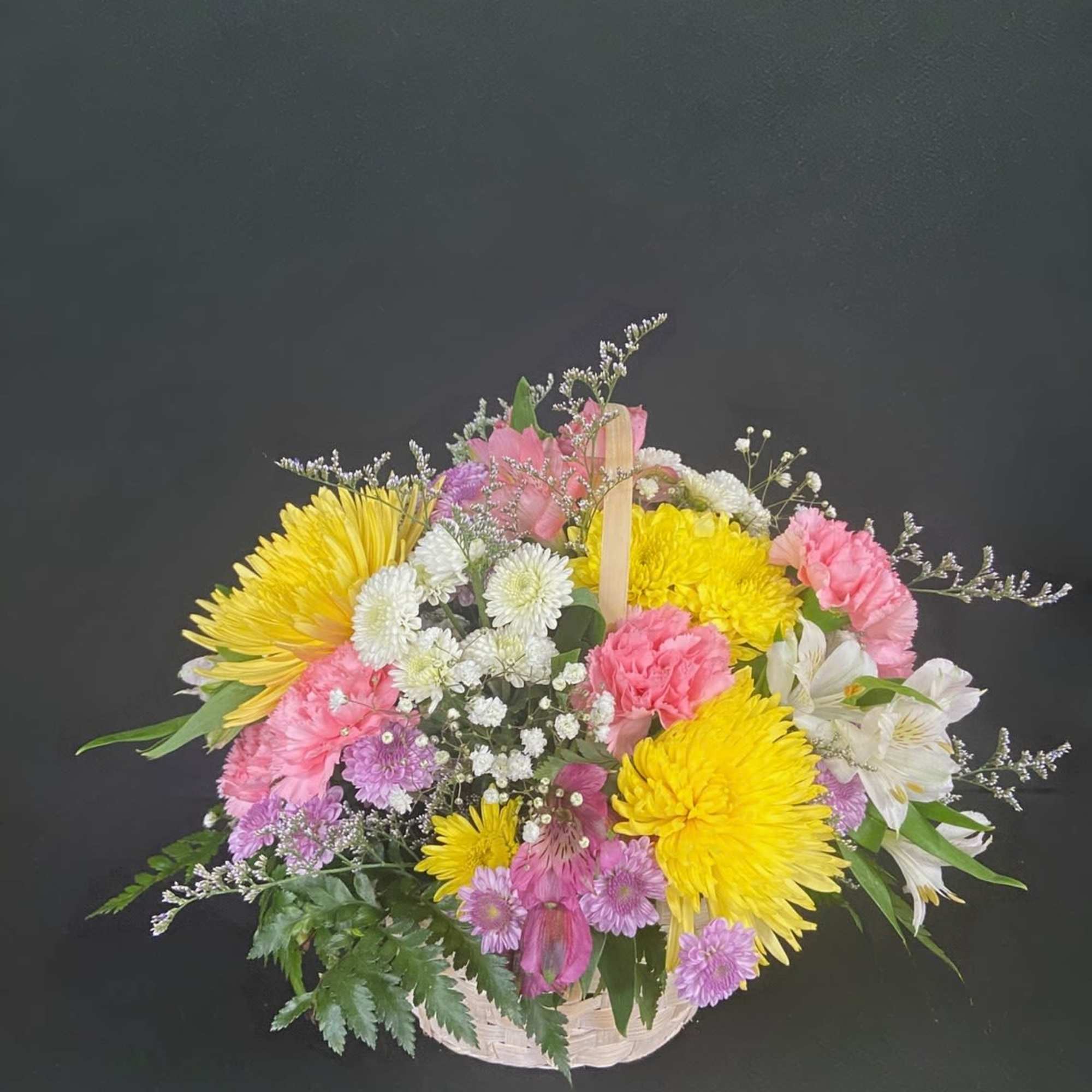 A basket of bright, colorful flowers to pick up anyone's spirits. Includes