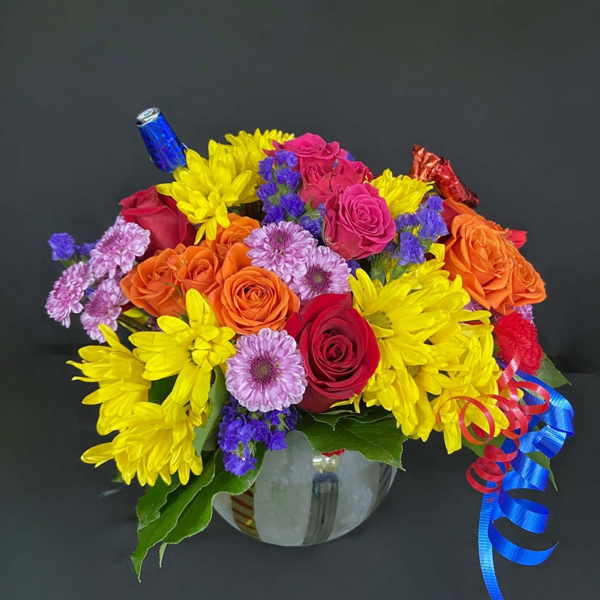 A frosted globe is decorated with birthday candles and filled with seasonal