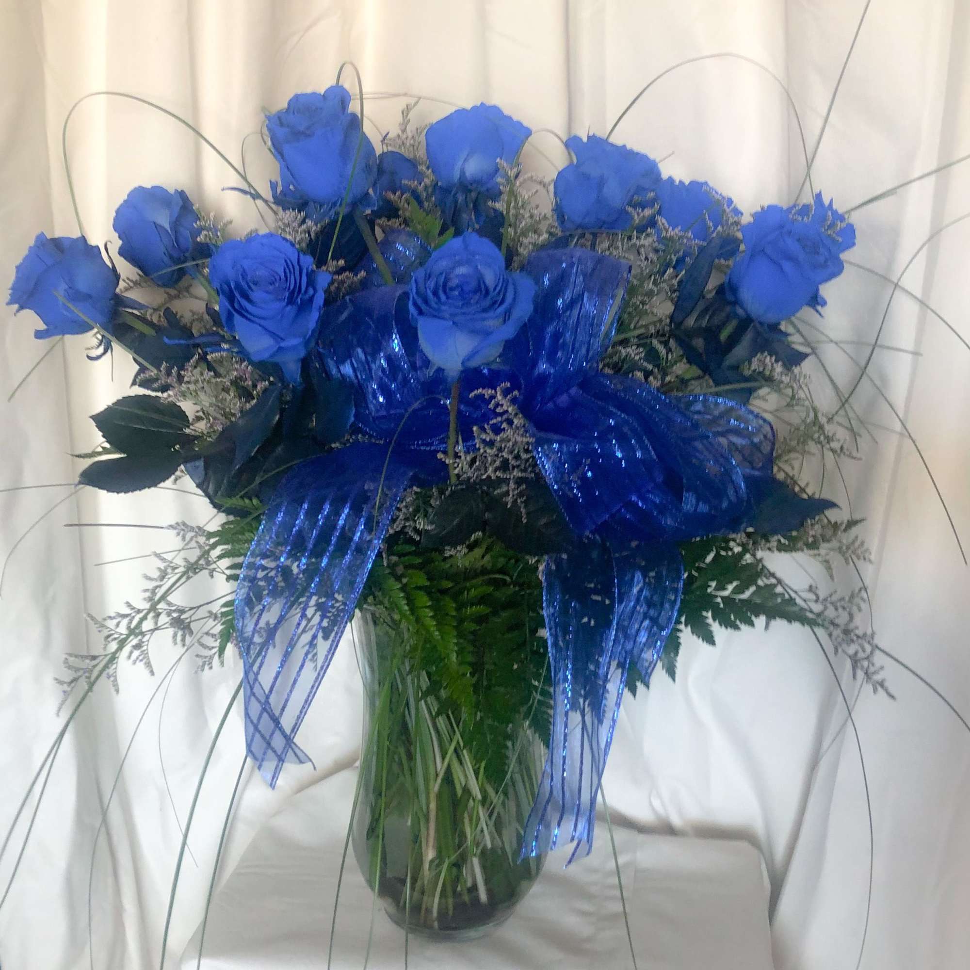A dozen blue roses in a custom vase.