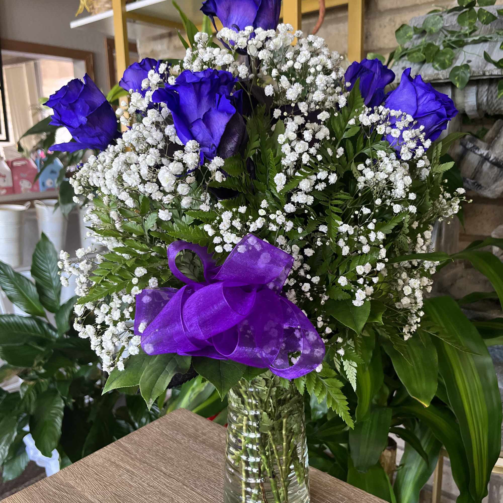 purple roses in vase with greenery and baby breath 