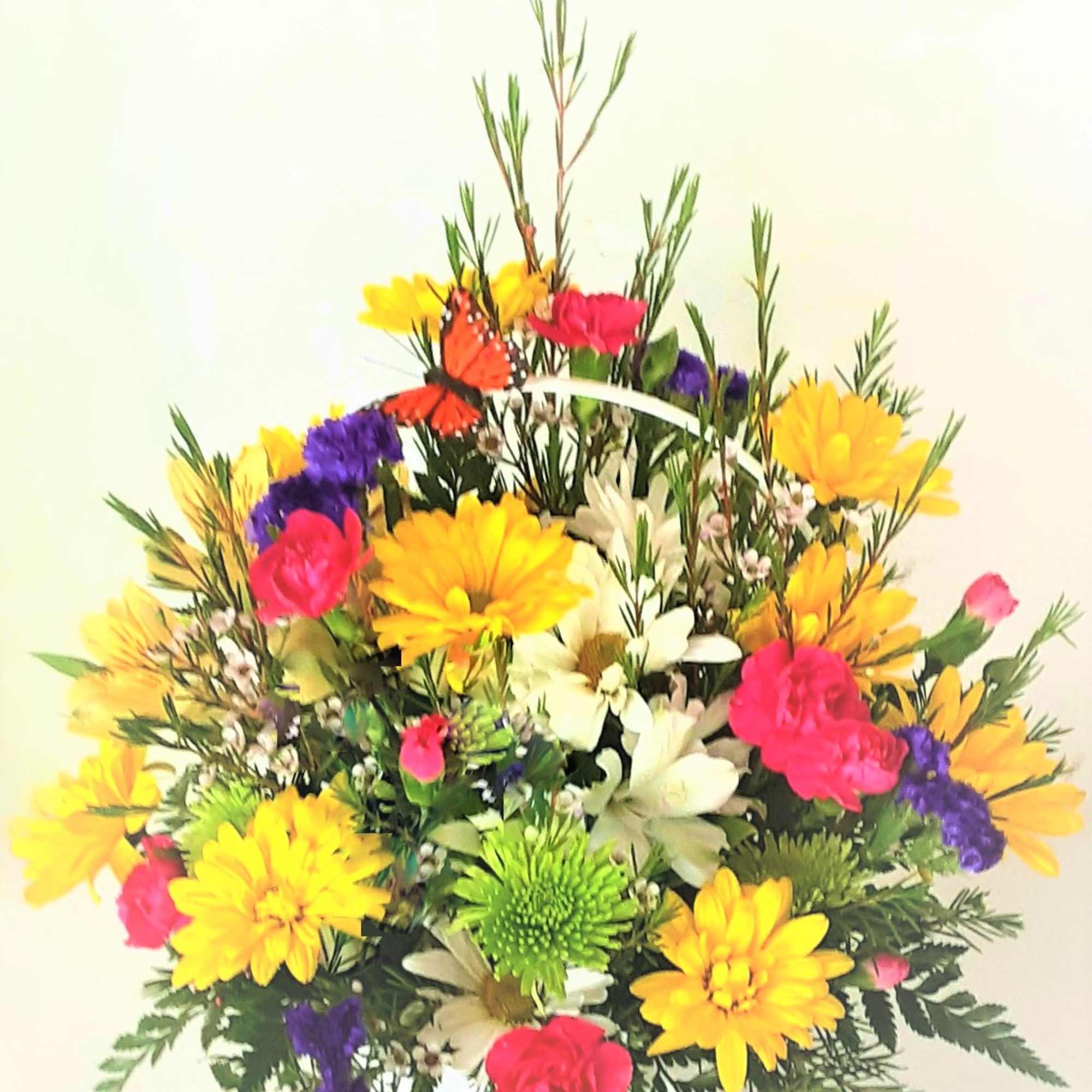 Colorful mixed flower arrangement in a white basket