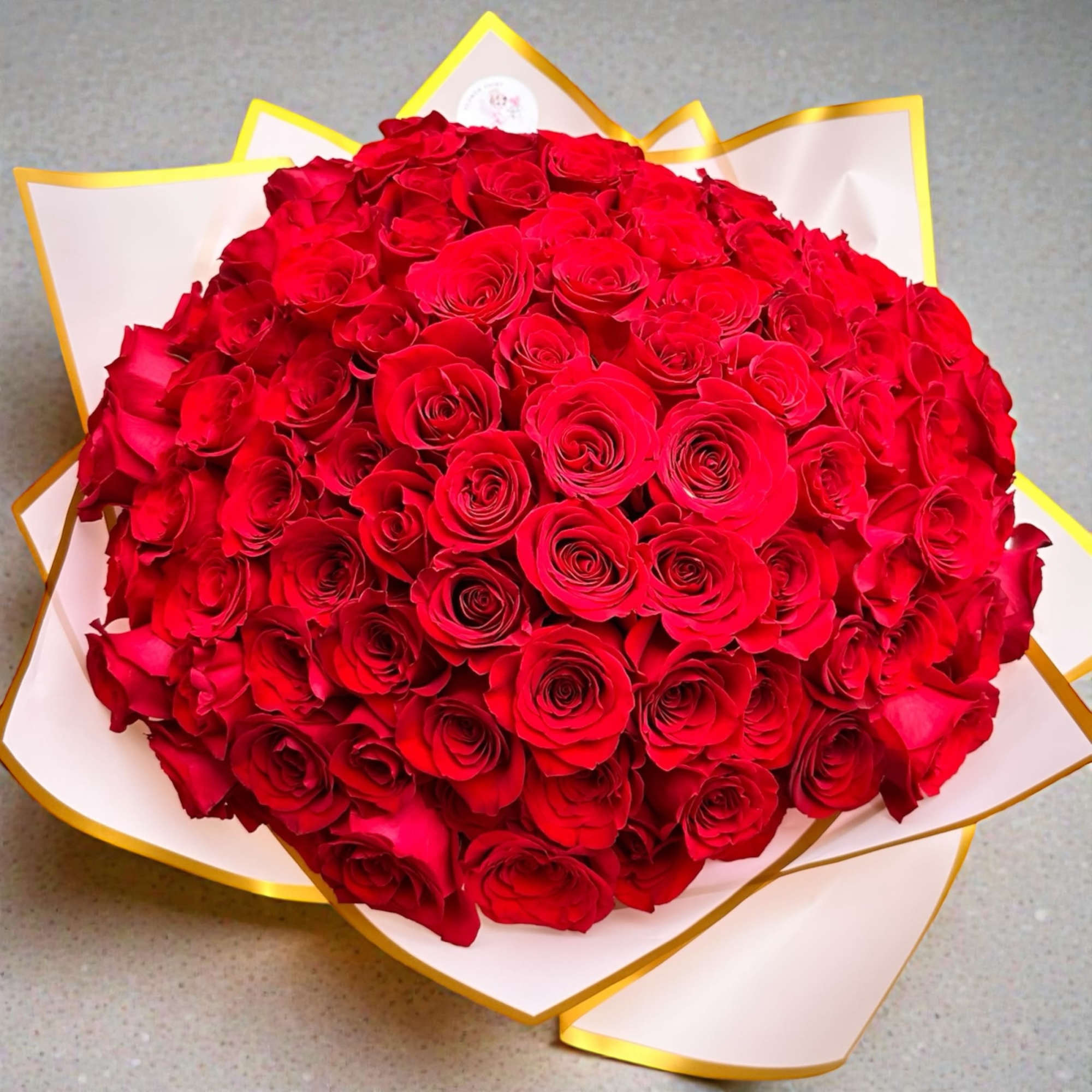 The Ramo Buch&oacute;n 100 Wrapped Roses Arrangement is a luxurious floral statement