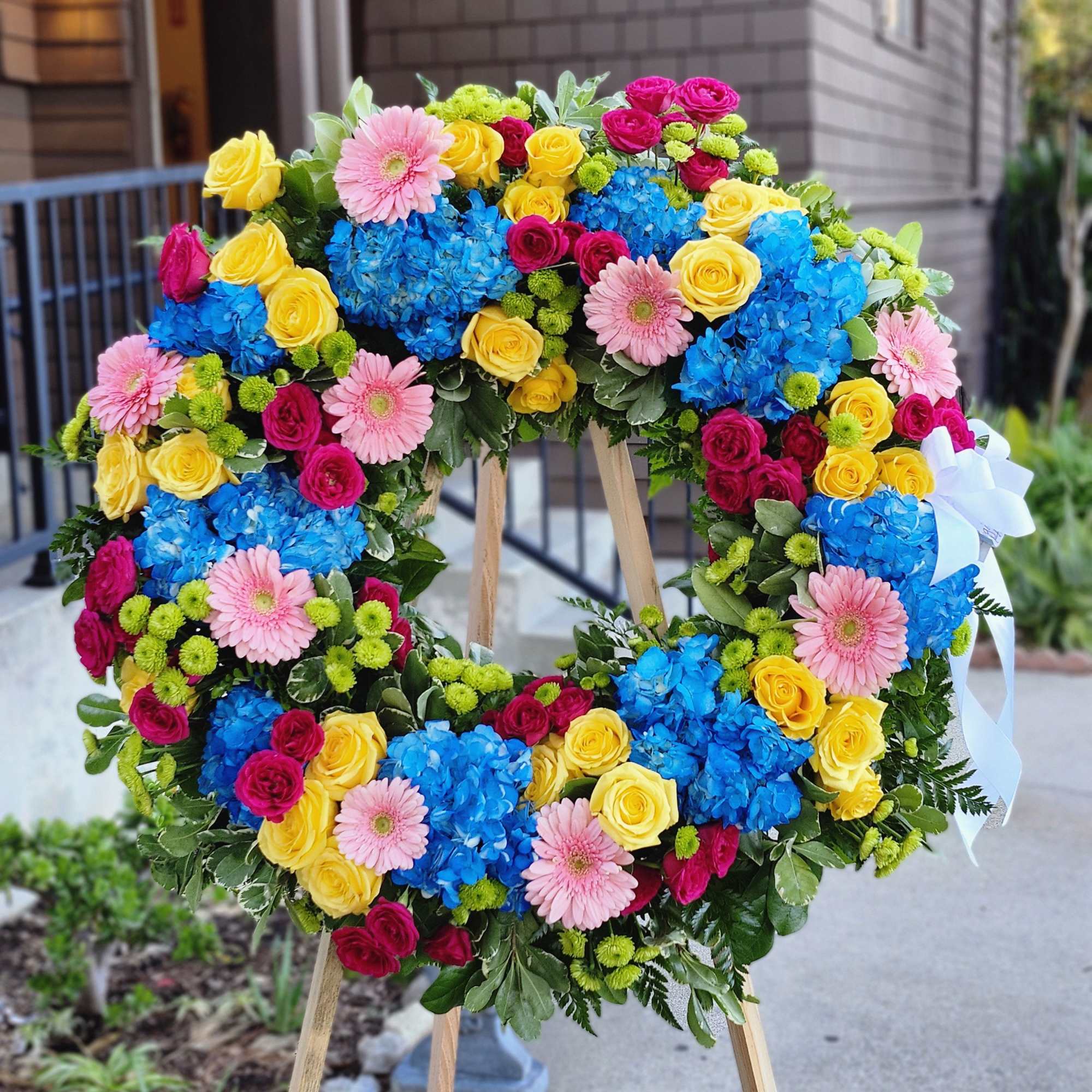 This colorful and bright wreath spray is representative of a life lived