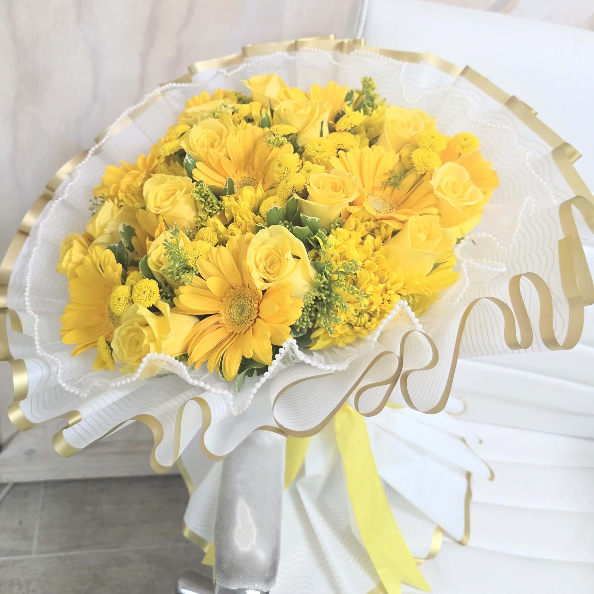 Premium wrapped bouquet with pearl sheer trim and a mix of yellow