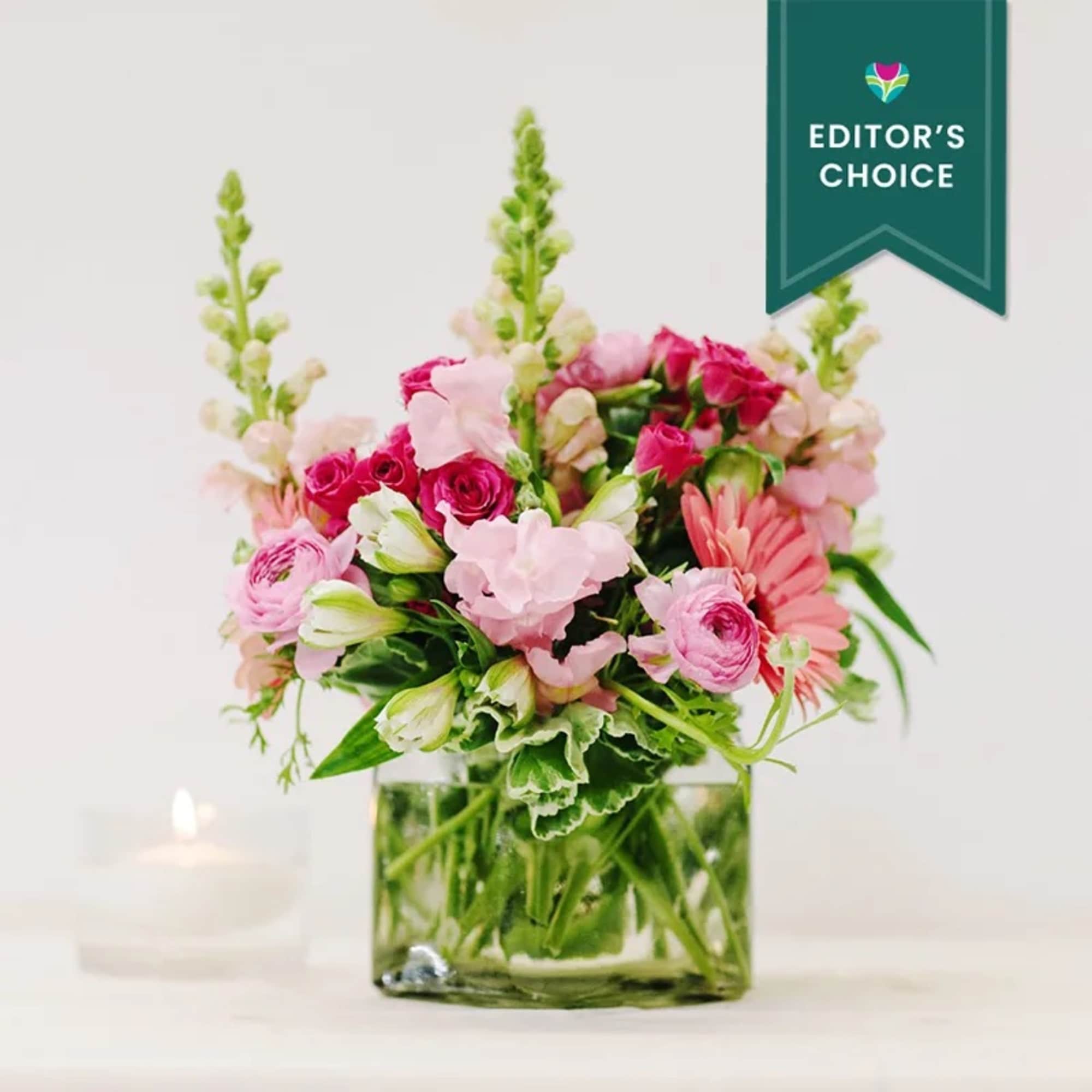Pink mixed flower arrangement in a square glass vase