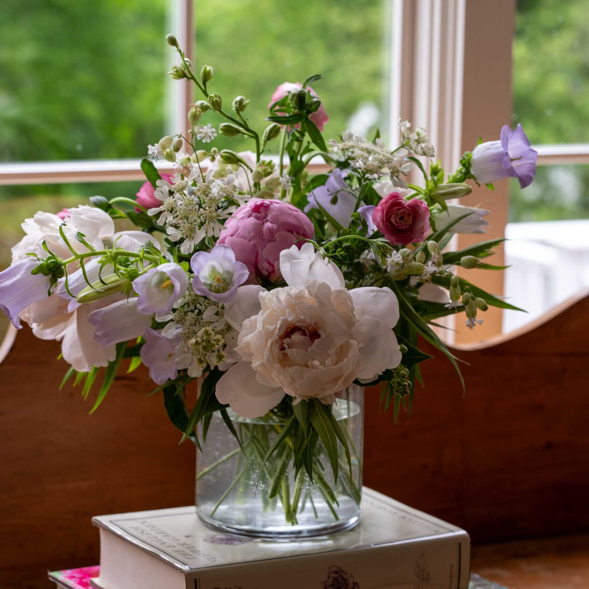 Spring peonies, campanula, ranunculus as well as sweet peas in a soft