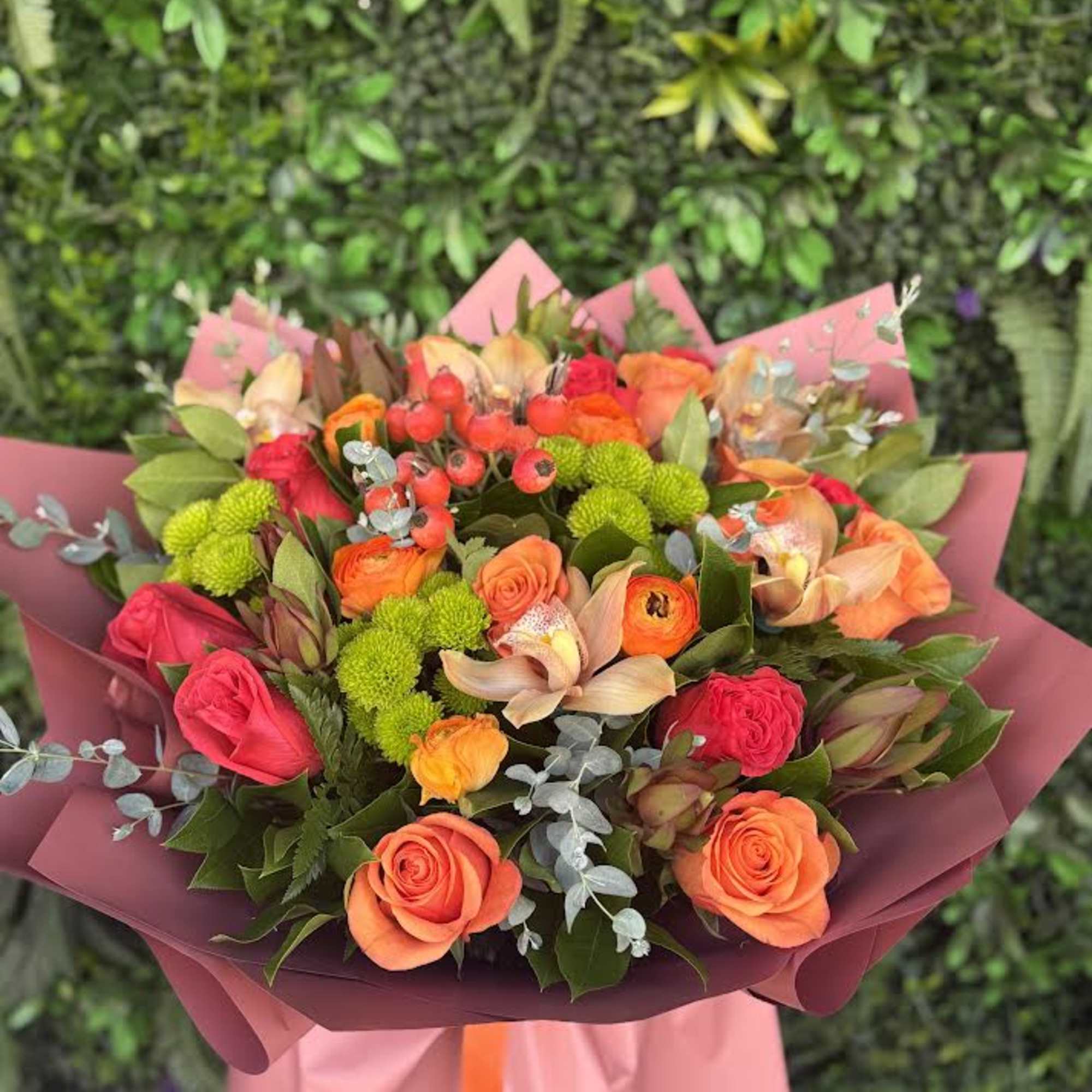A vibrant summer bouquet bursting with warm shades of orange, coral, and