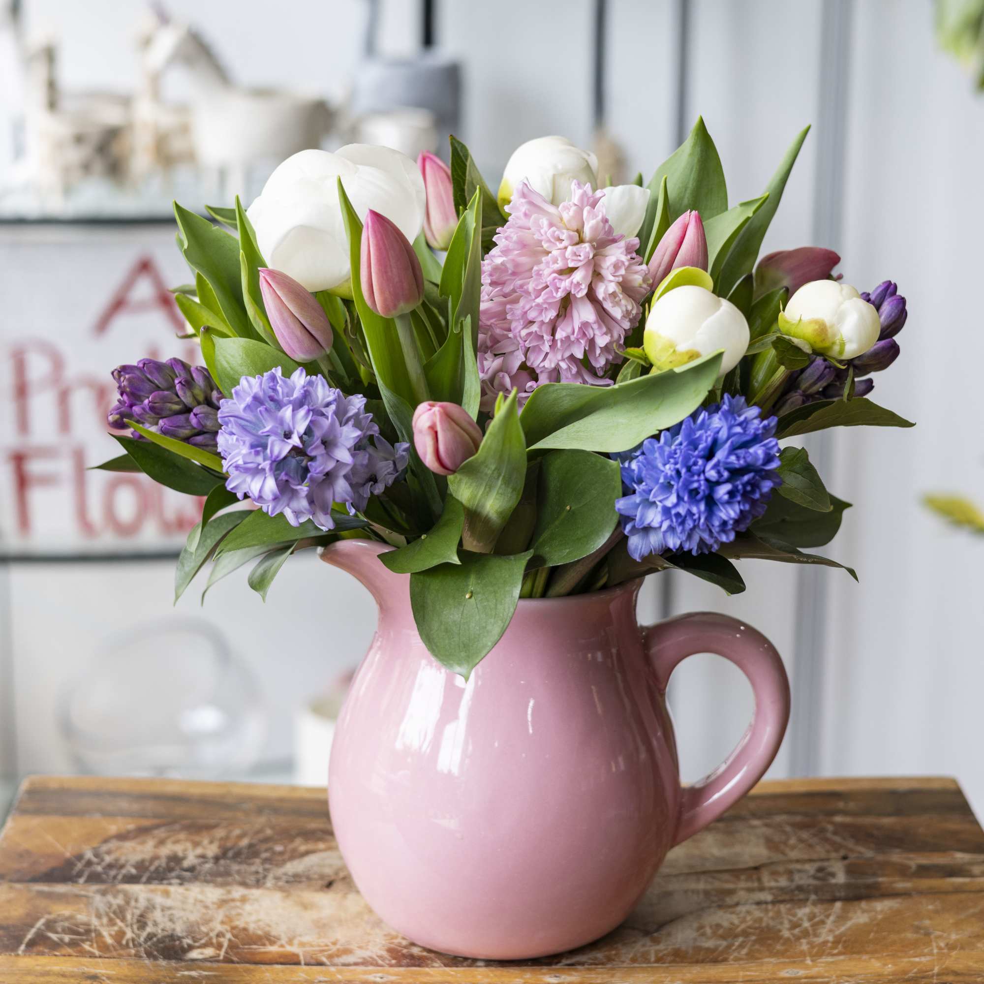 Pitcher full of spring time flowers. Pitcher will be pink, purple, green