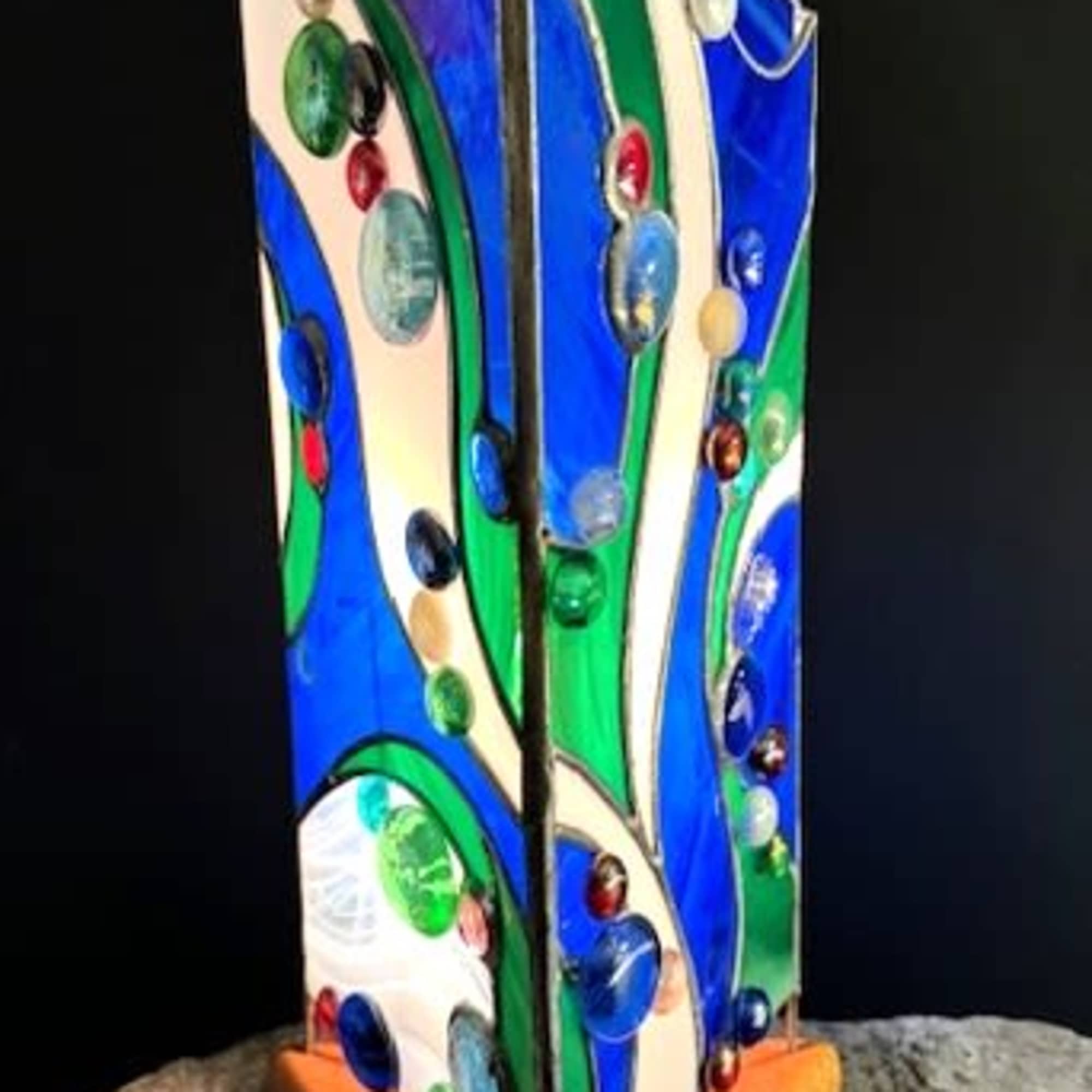 A vertical stained-glass sculpture that reads like a ripple of sea glass-this
