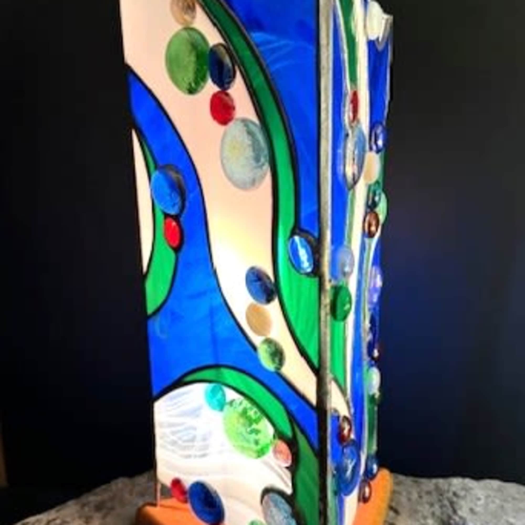 A vertical stained-glass sculpture that reads like a ripple of sea glass-this