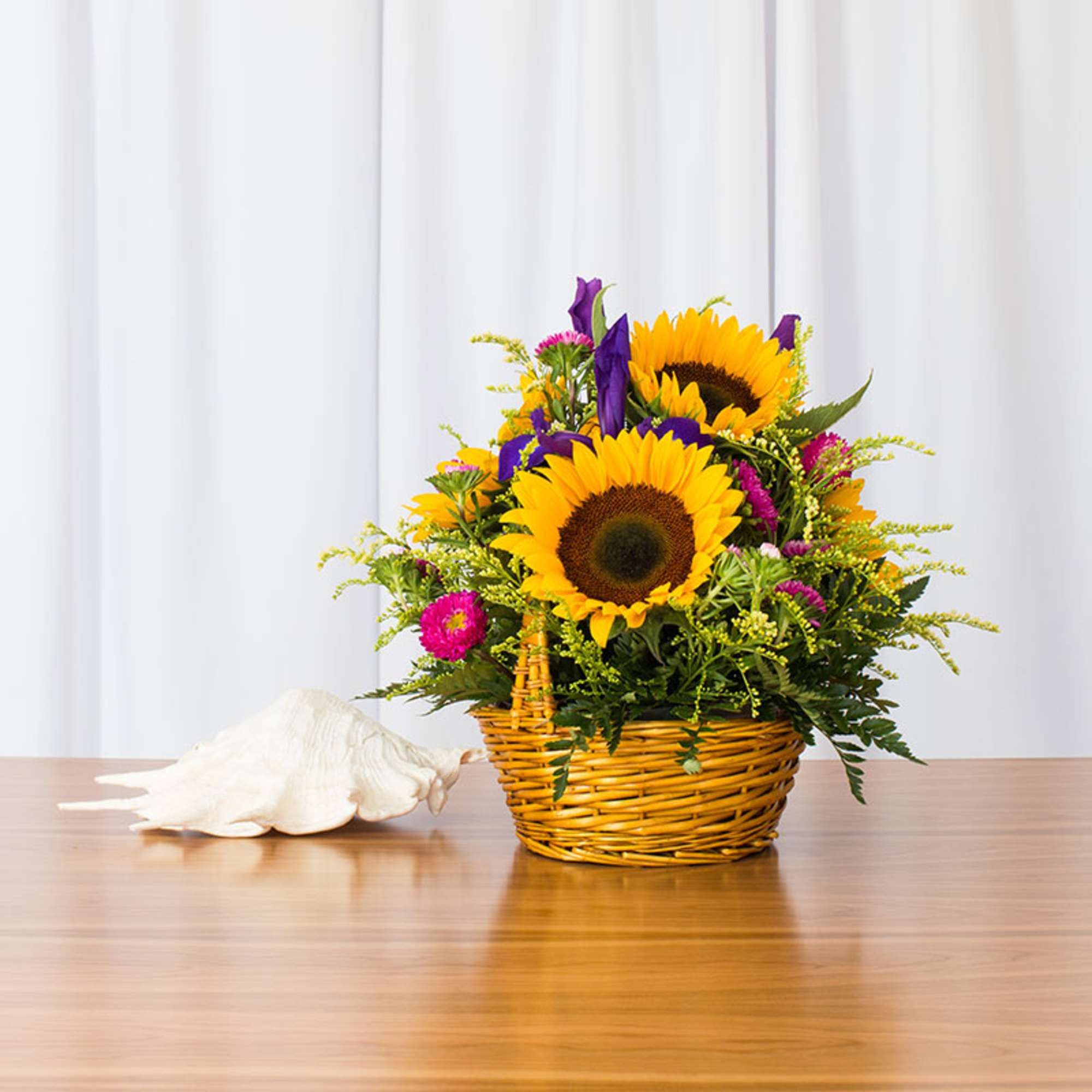 Brighten anyone's day with this delightful basket featuring sunflowers, asters, and more.