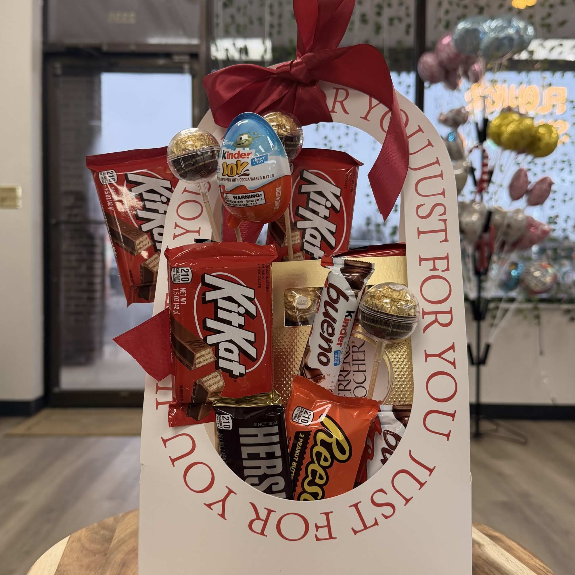 Candy gift bag with assorted chocolate bars and a red ribbon bow