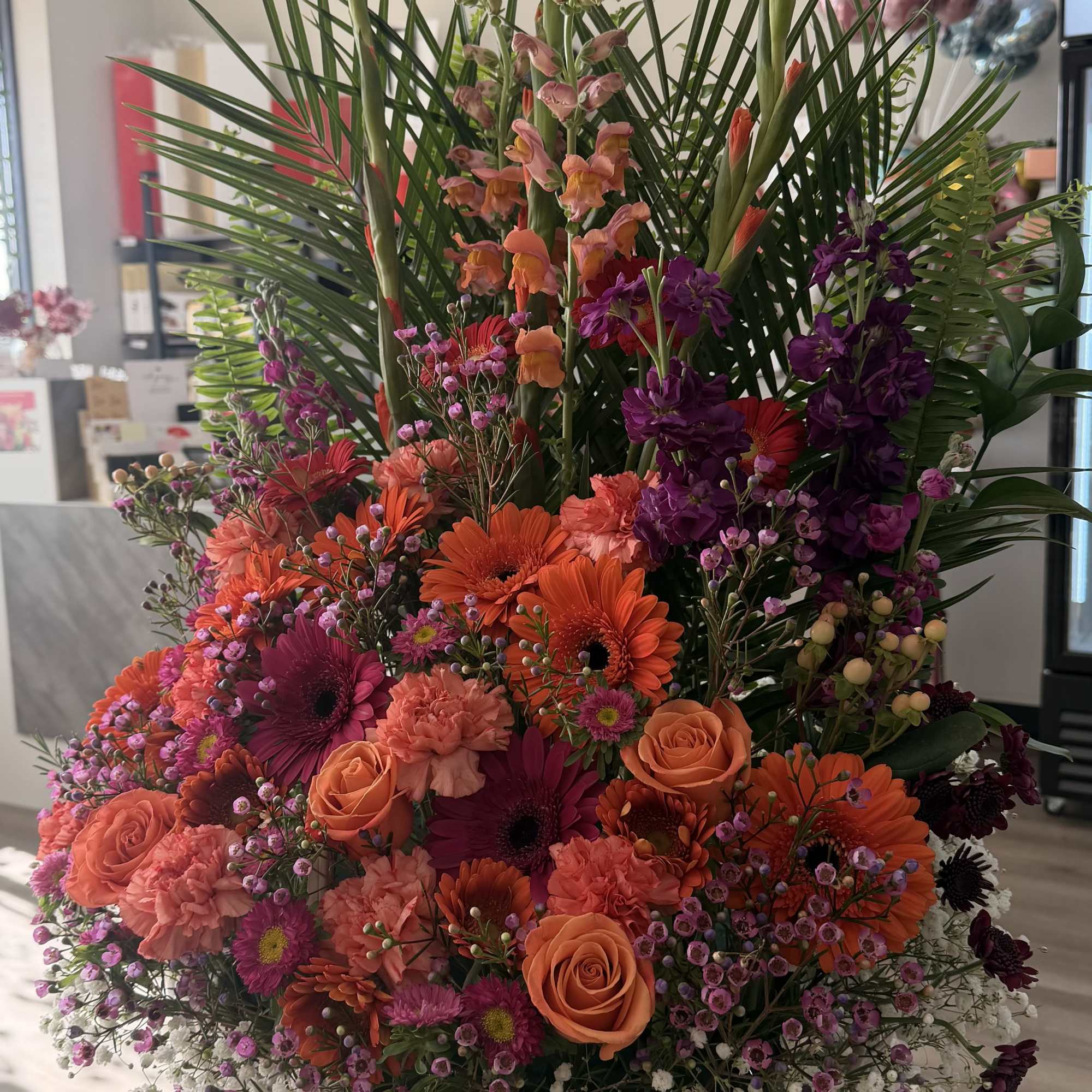Large basket arrangement of orange, pink, and purple flowers