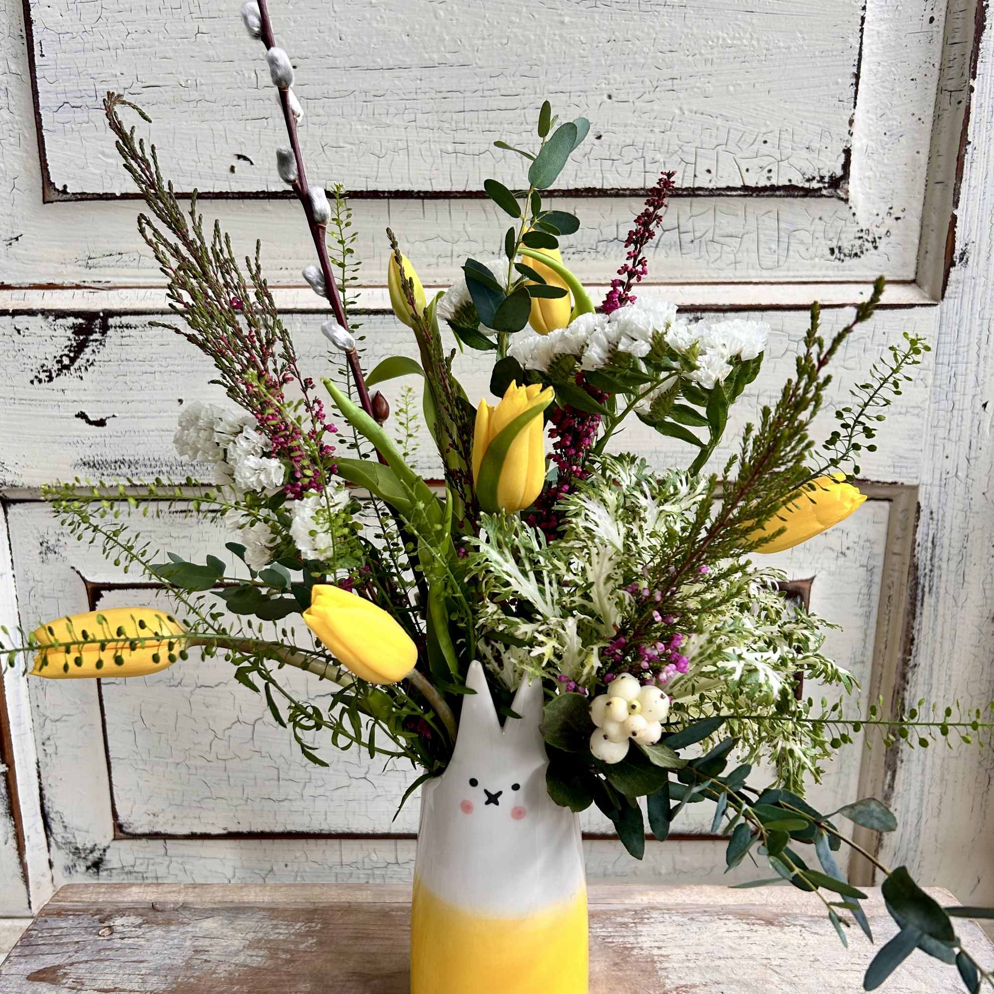 A ceramic bud vase with the details of an adorable bunny is