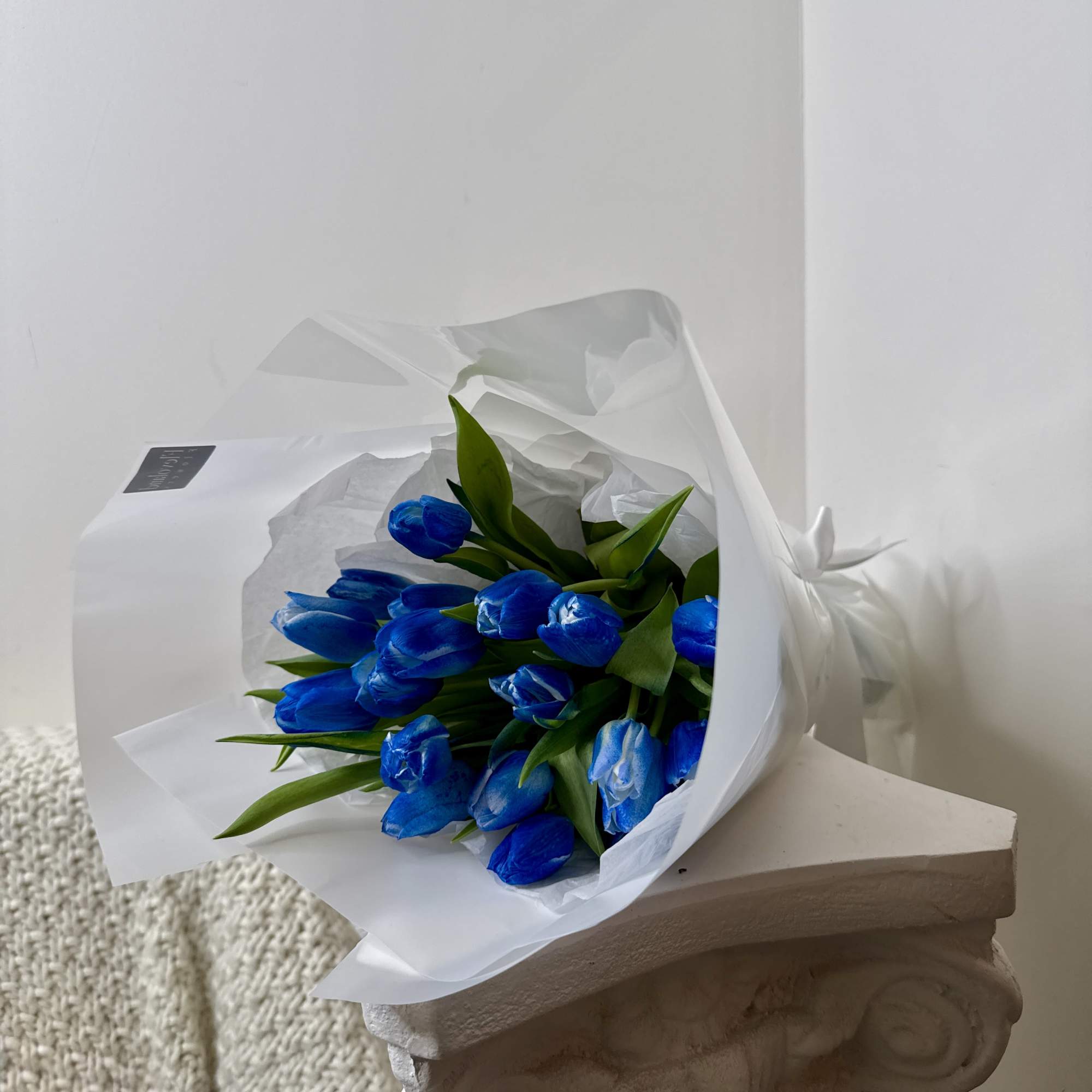 A bouquet of 10 tulips in deep, marbled shades of blue wrapped