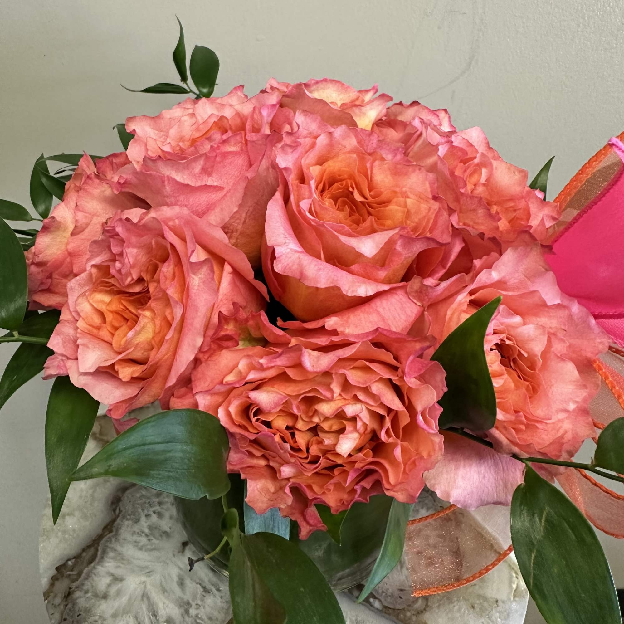 A dozen free spirit roses in a modern styled shorter vase with