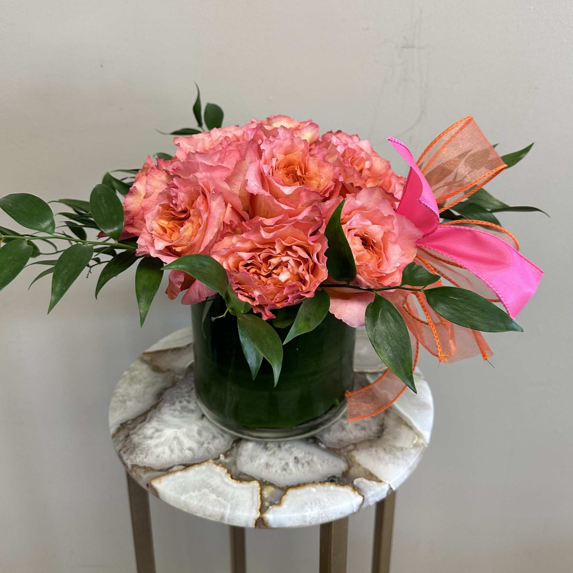 A dozen free spirit roses in a modern styled shorter vase with