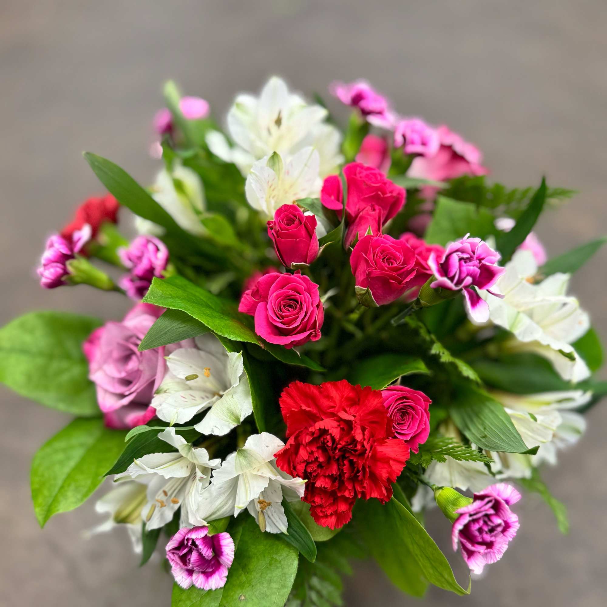 A bright and happy mix of mini hot pink spray roses, red