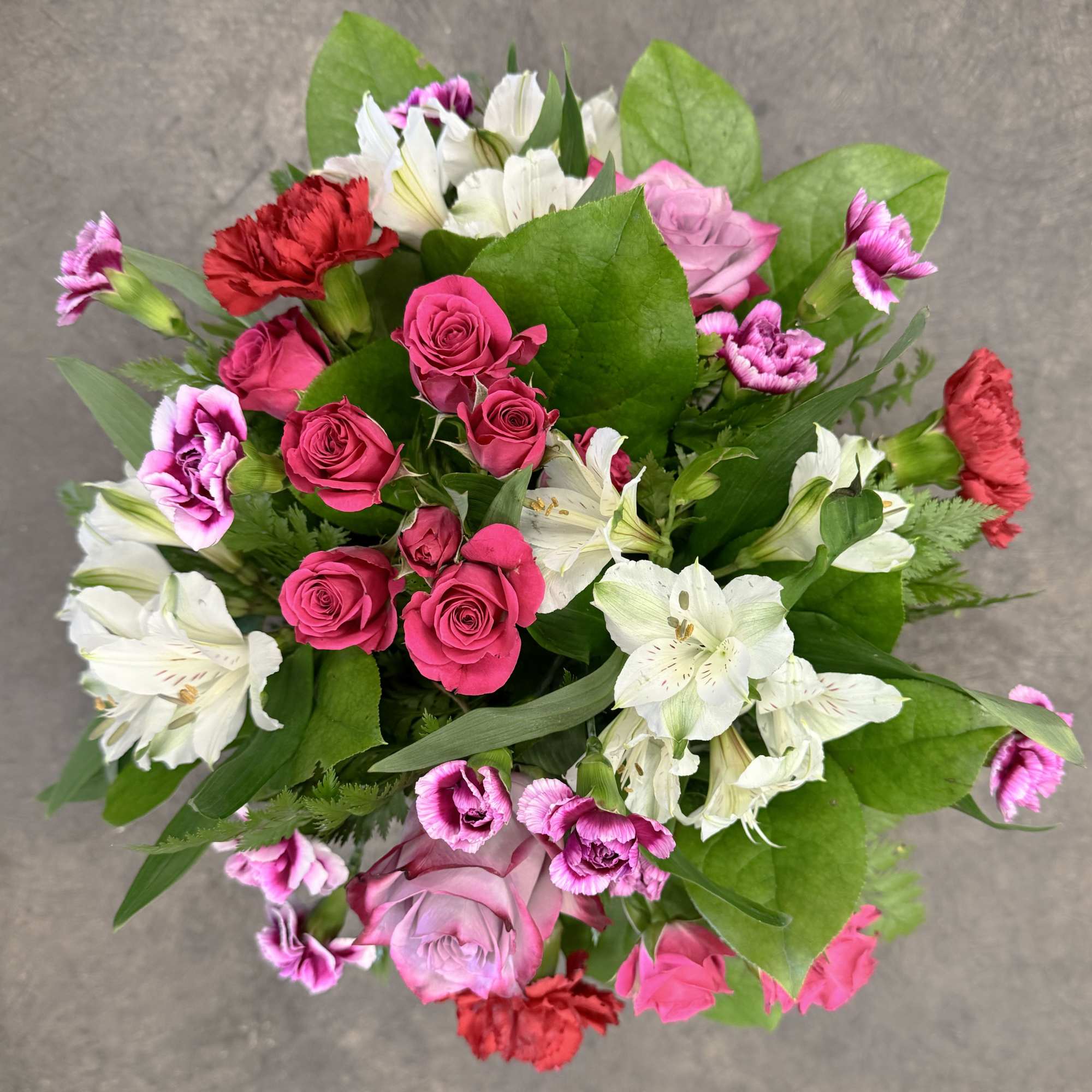 A bright and happy mix of mini hot pink spray roses, red