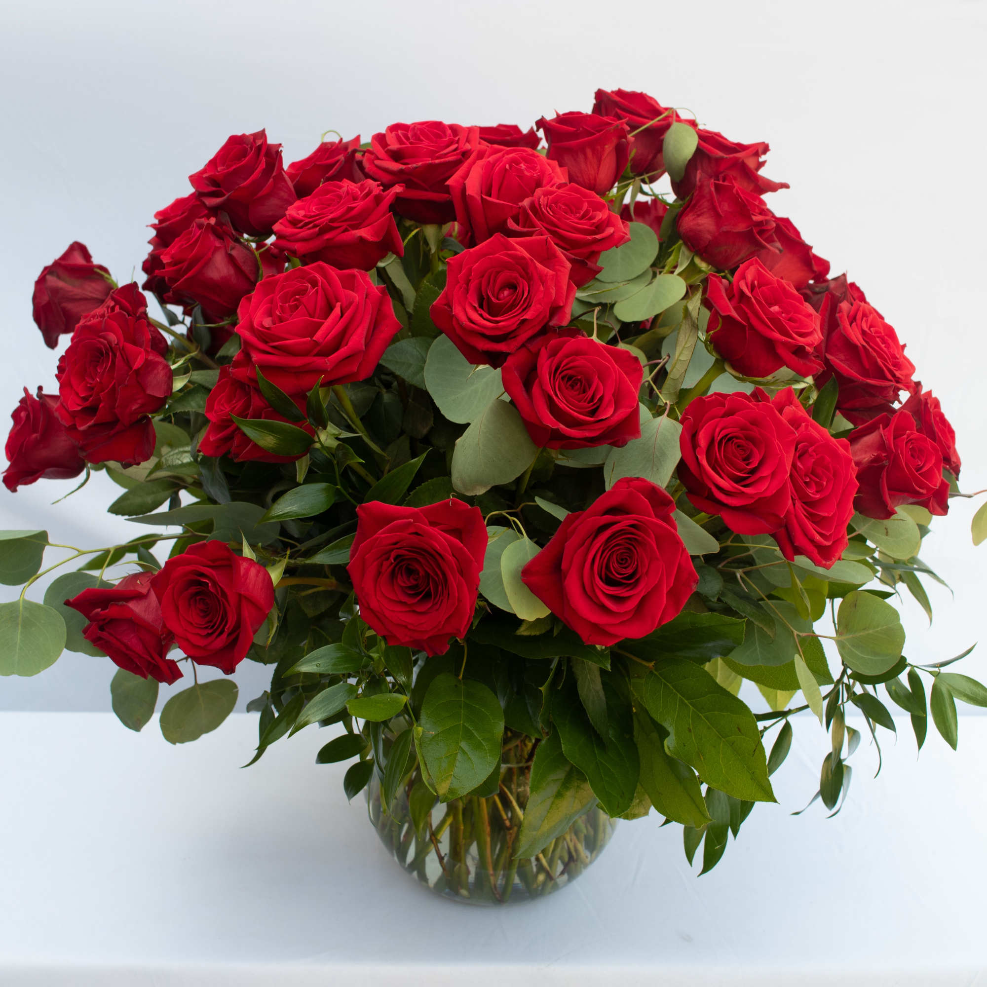 50 PREMIUM ECUADORIAN RED ROSES ARRANGED IN A GLASS FLUTED BOWL WITH