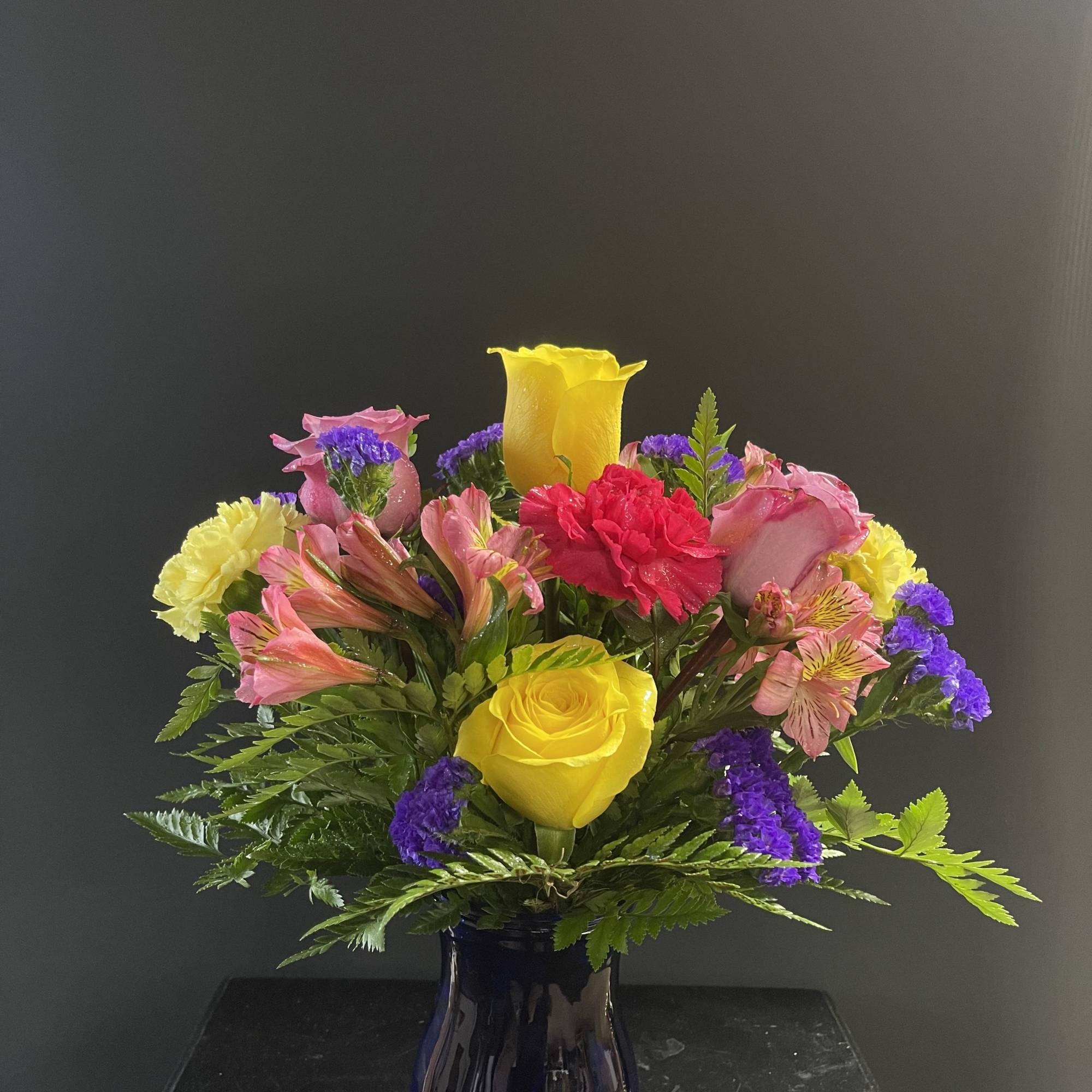 A fun and bright arrangement with carnations, alstroemeria, and monte casino.
