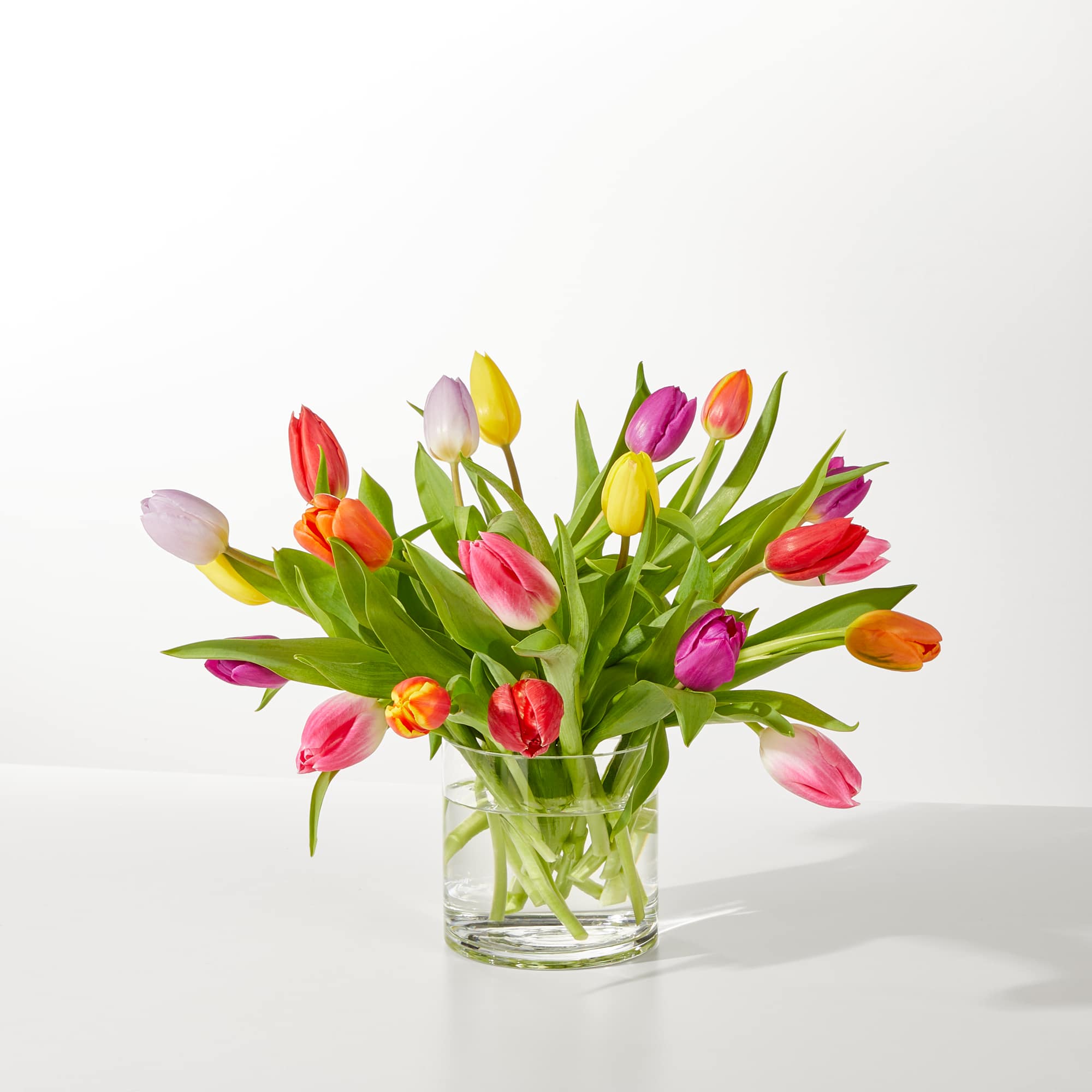 Colorful tulips arranged in a clear glass vase