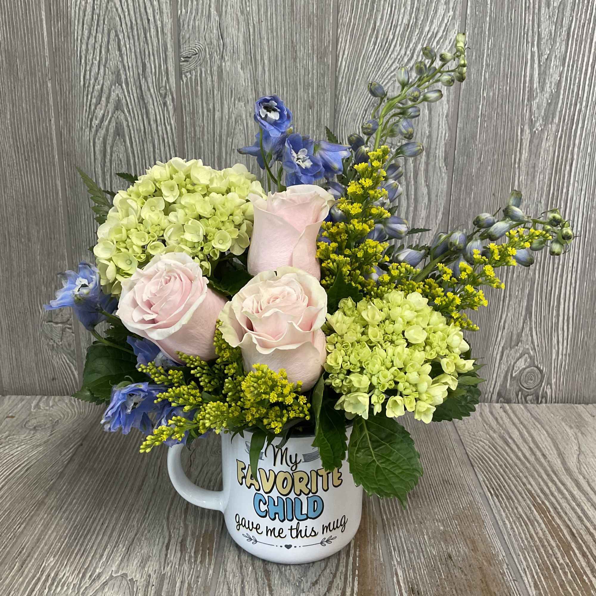 A soft floral arrangement in a funny keepsake mug - a perfect