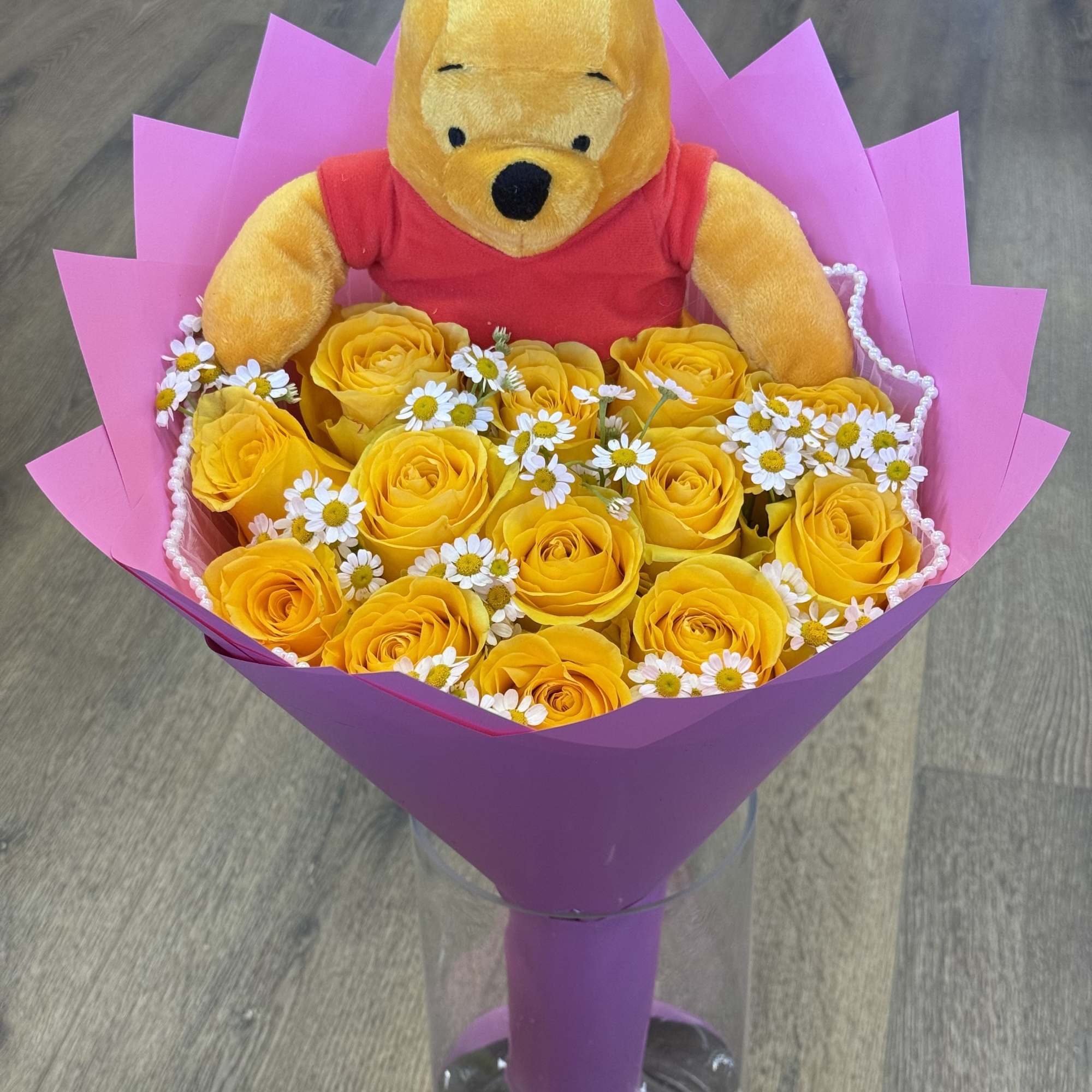 12 Yellow Roses mixed with baby's breath. Wrapped in light pink paper