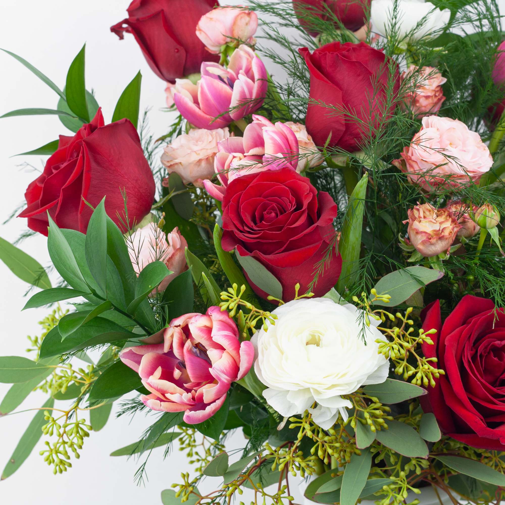 Bouquet of red and pink roses with white blooms and greenery