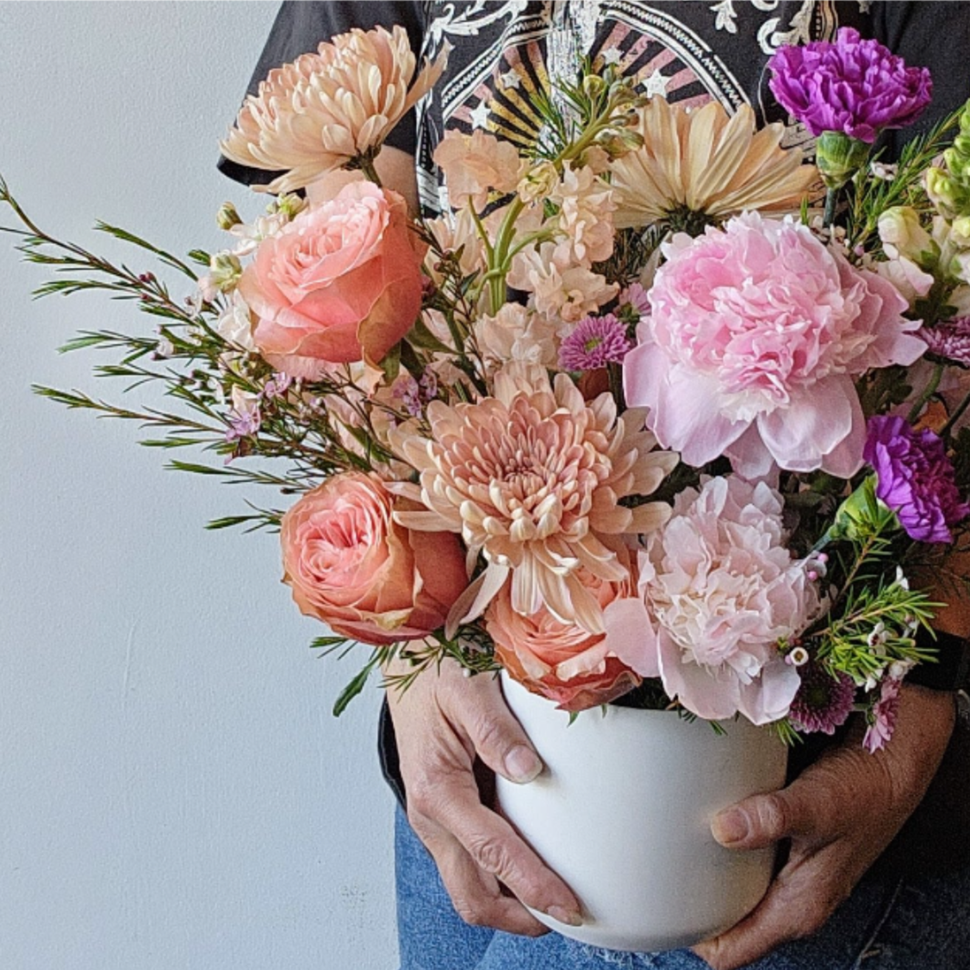 An abundant, garden-style arrangement designed with lush layers of soft spring blooms