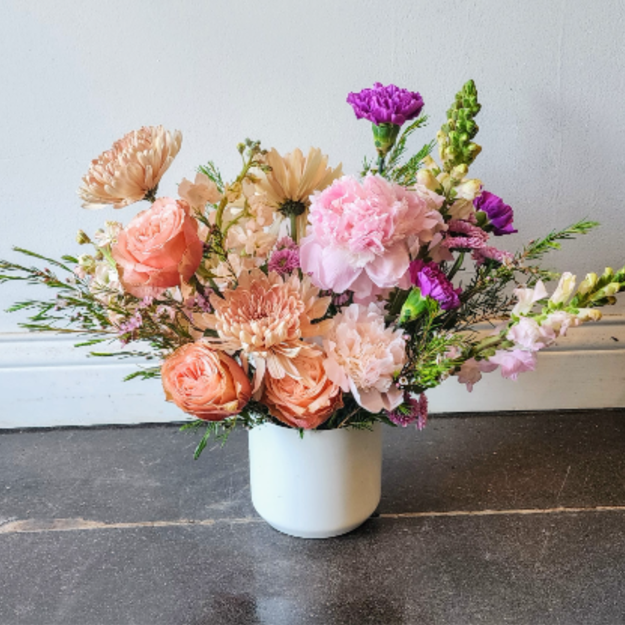 An abundant, garden-style arrangement designed with lush layers of soft spring blooms
