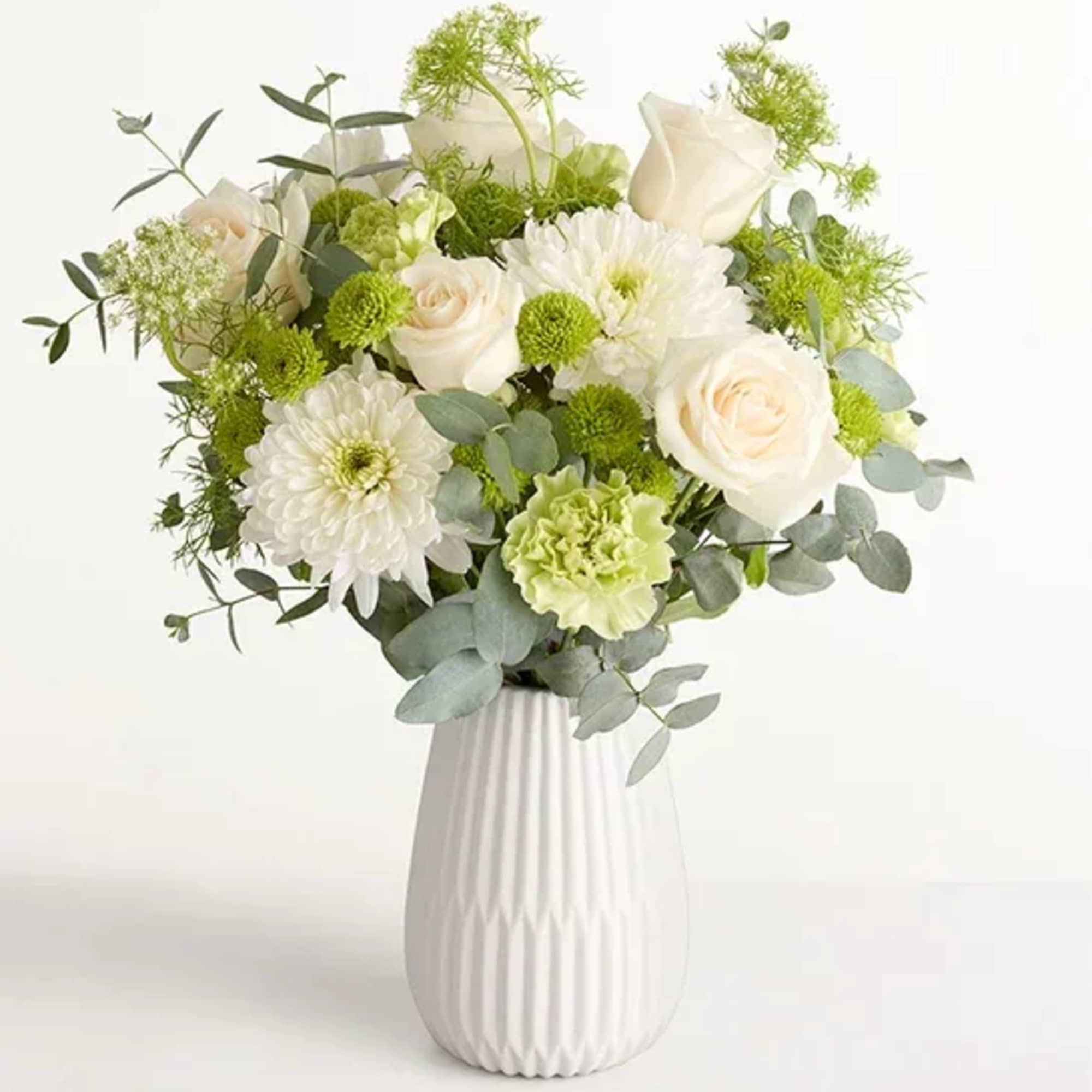 Soft white roses and full chrysanthemum blooms mingle with pale green button