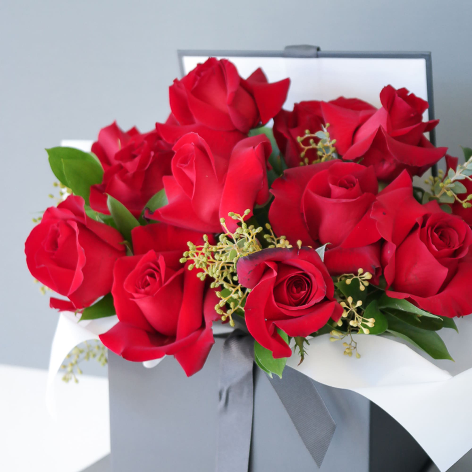 A romantic, modern floral gift box. This arrangement includes red roses and
