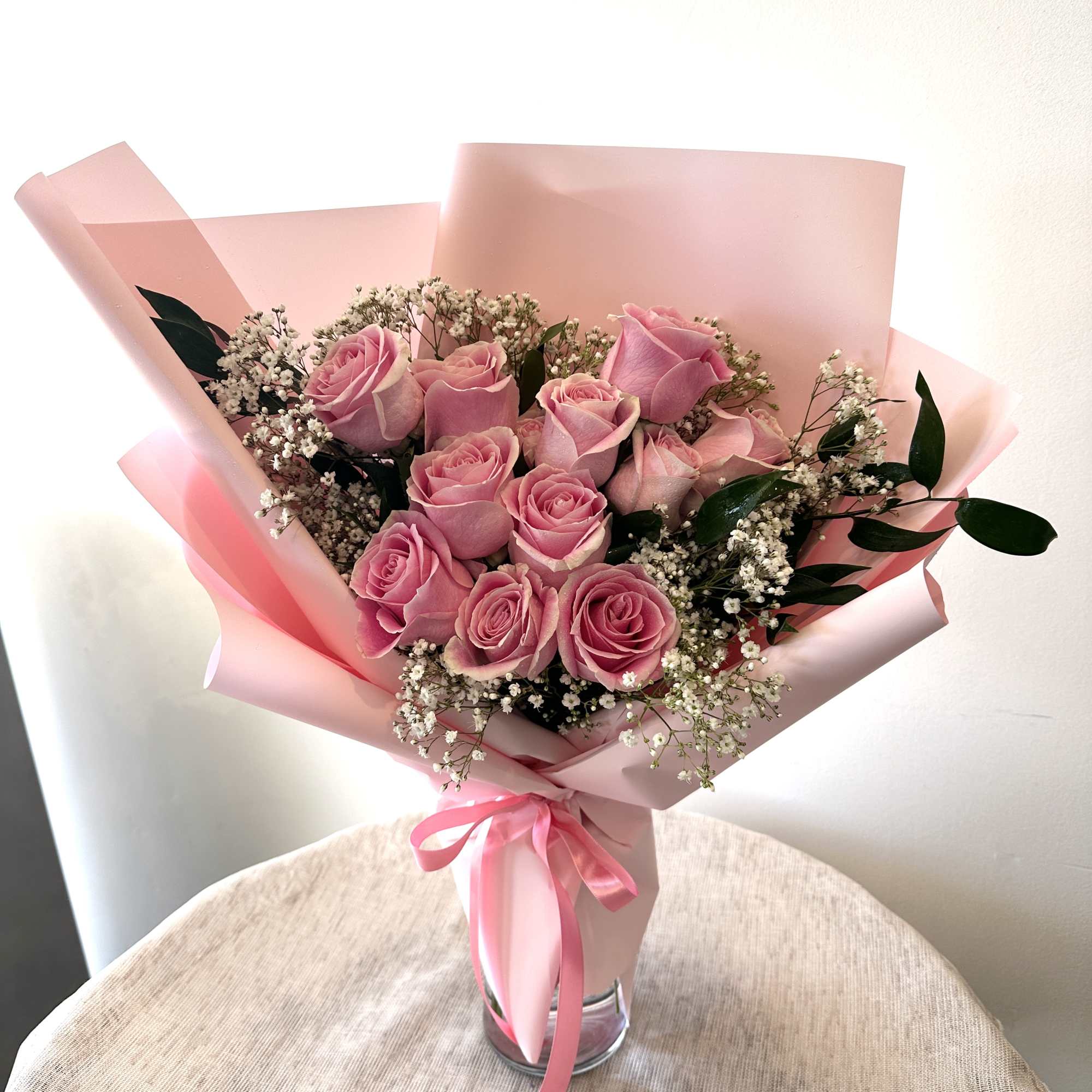 12 pink roses in a hand bouquet