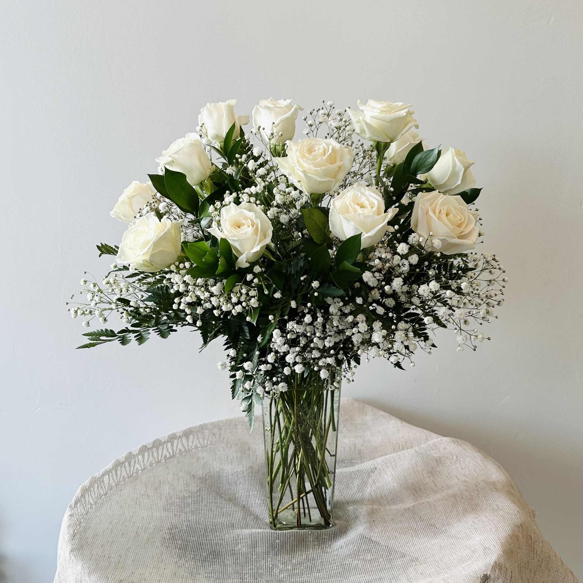 Pure joy! One dozen wondrous white roses take center stage in this