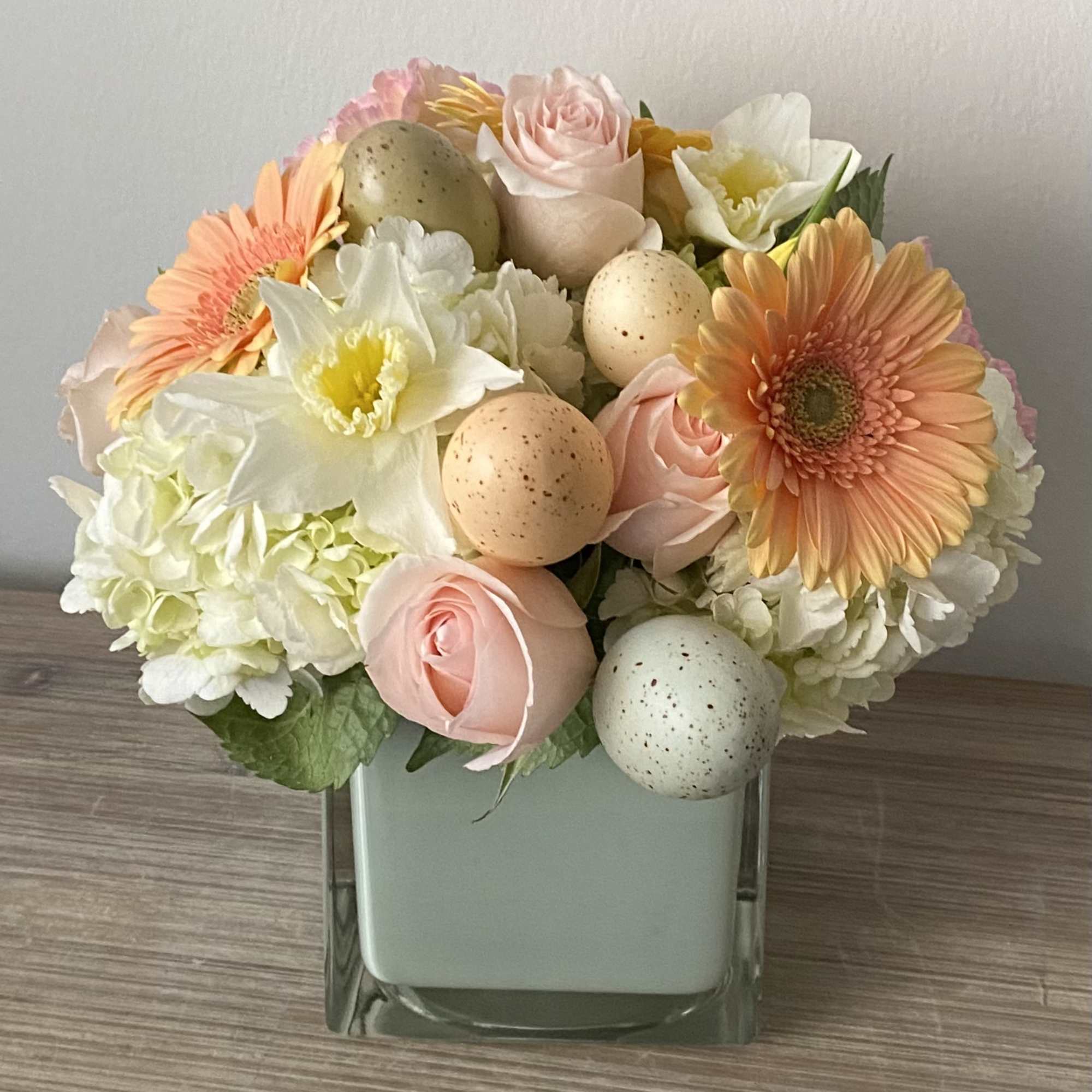 Compact Easter flower arrangement in 5&rdquo; glass cube with eggs 