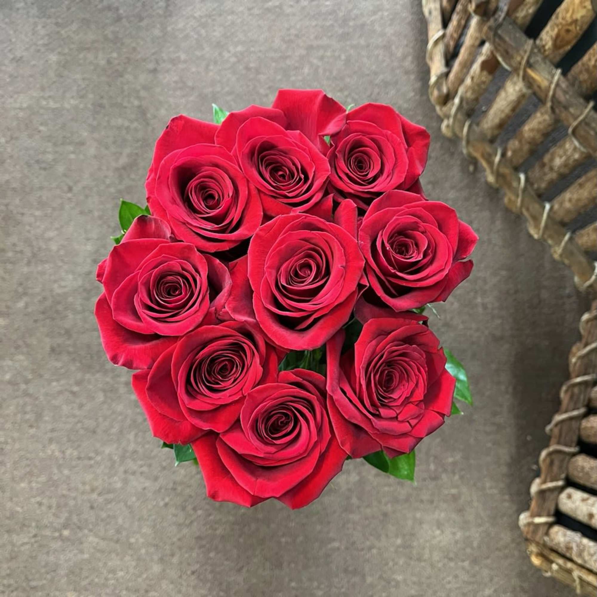 Nine long stem roses sitting on a cloud of hydrangea. 