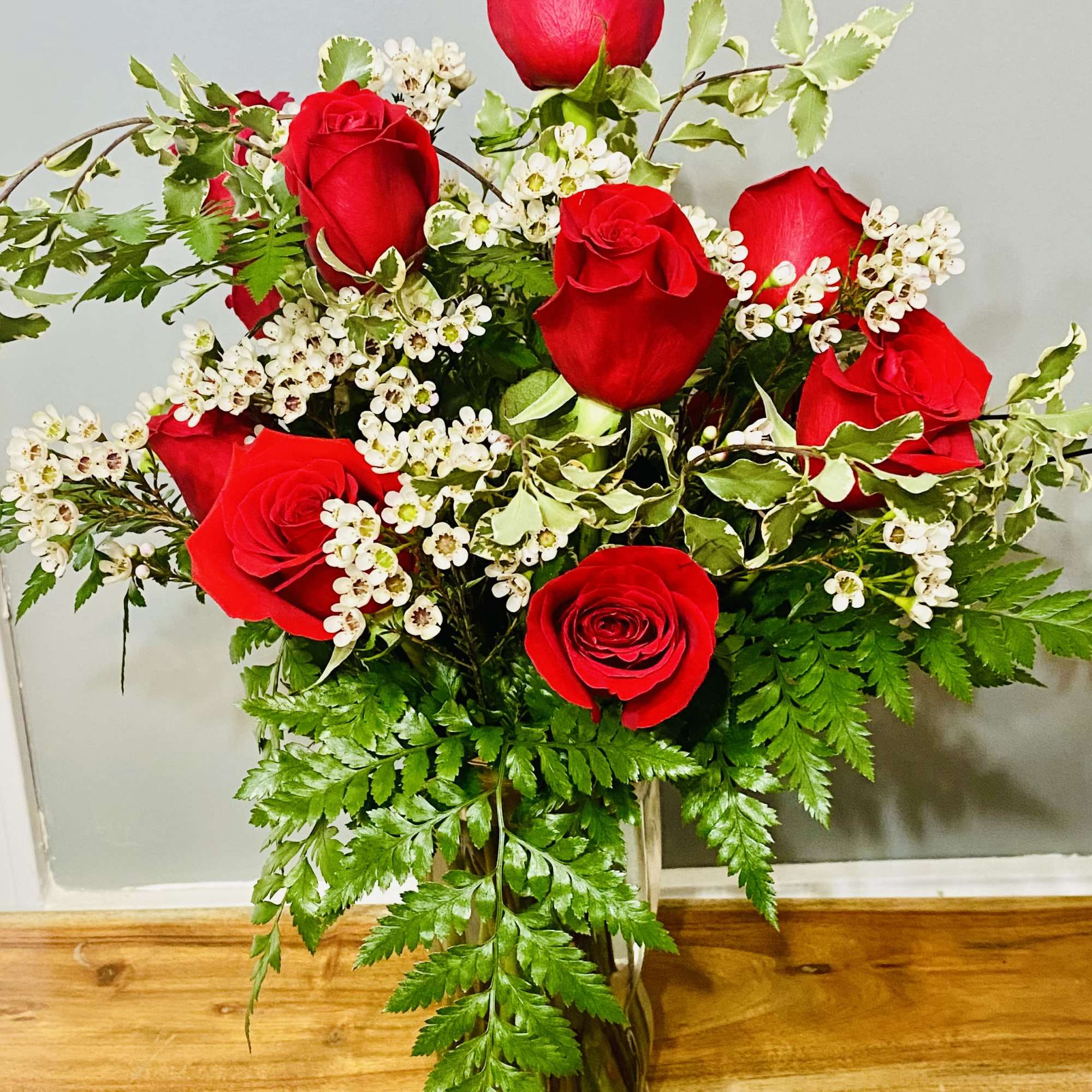 Long-stemmed red roses gathered in a clear glass vase make an unmistakable