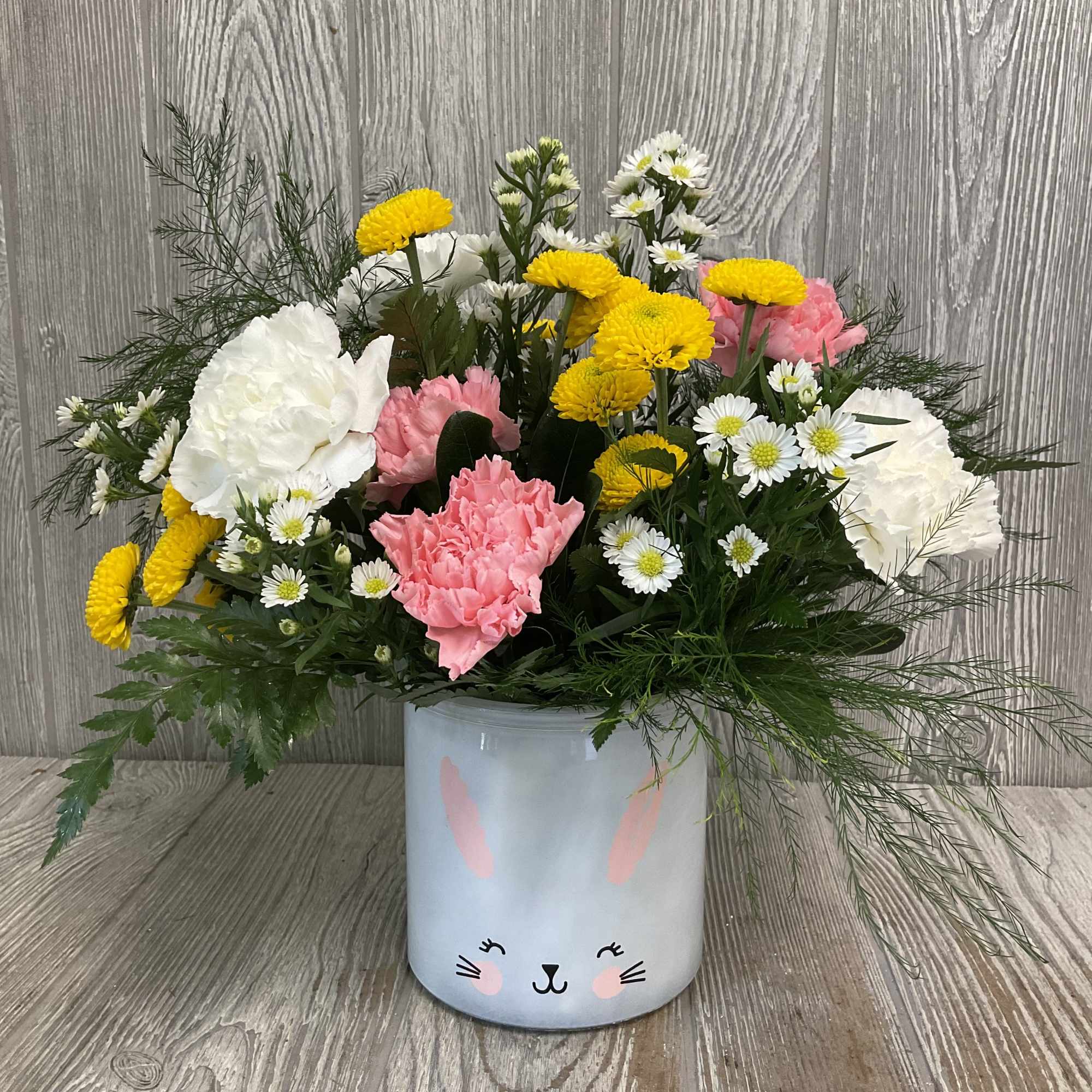 A fresh, springy arrangement in an adorable bunny vase. Colors and flowers
