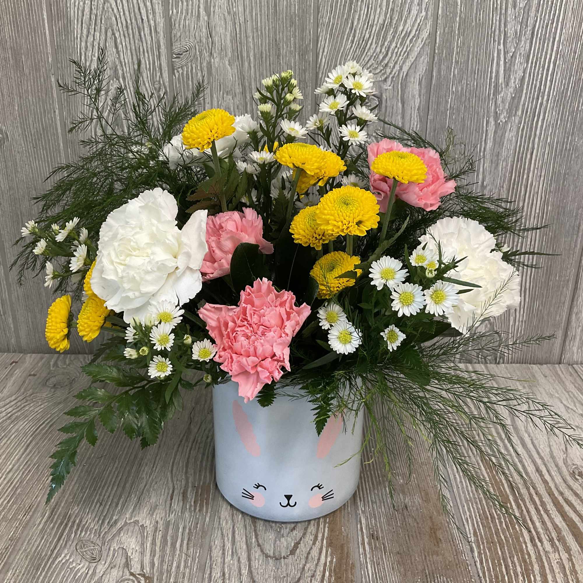 A fresh, springy arrangement in an adorable bunny vase. Colors and flowers