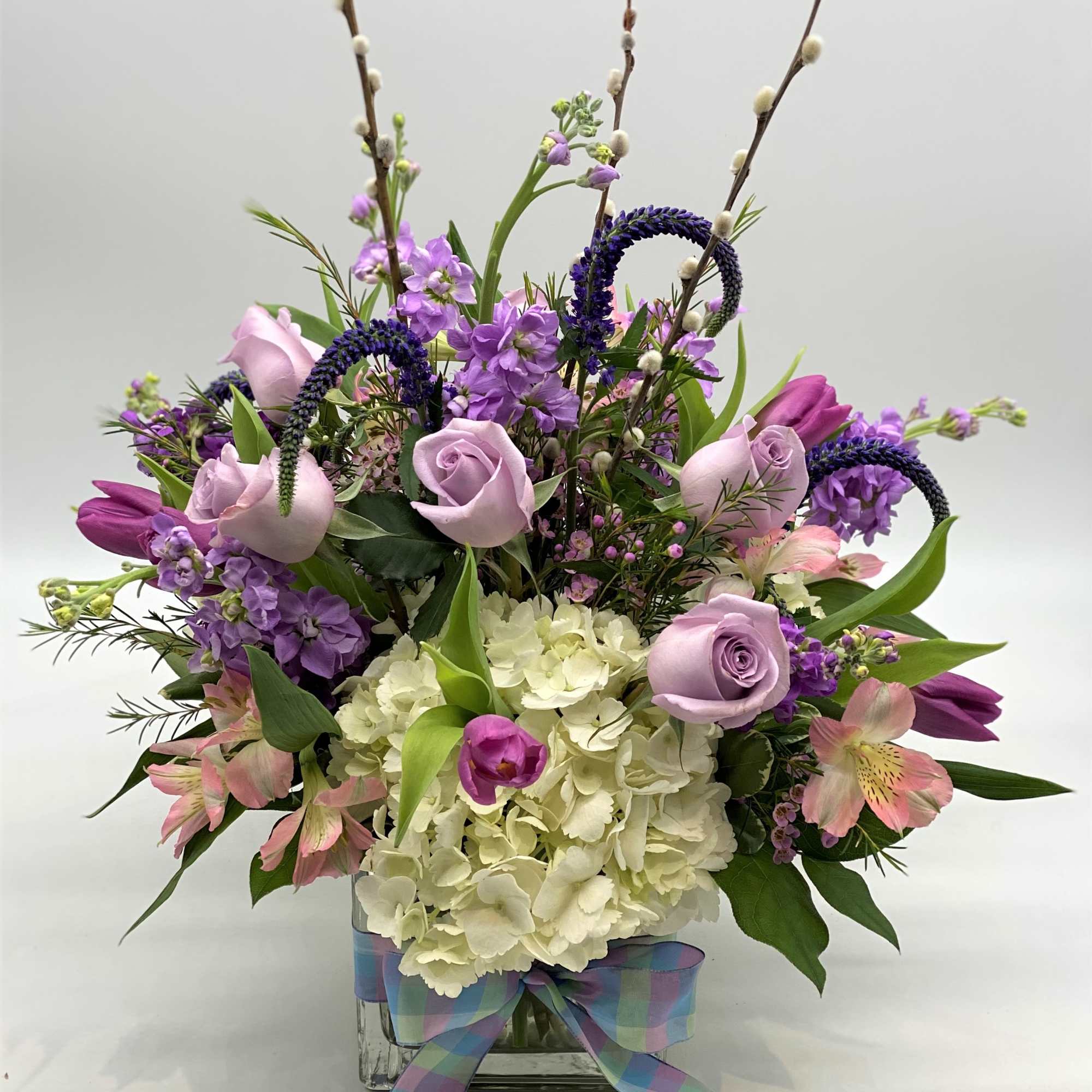A beautiful glass cube filled with white hydrangeas and various shades of