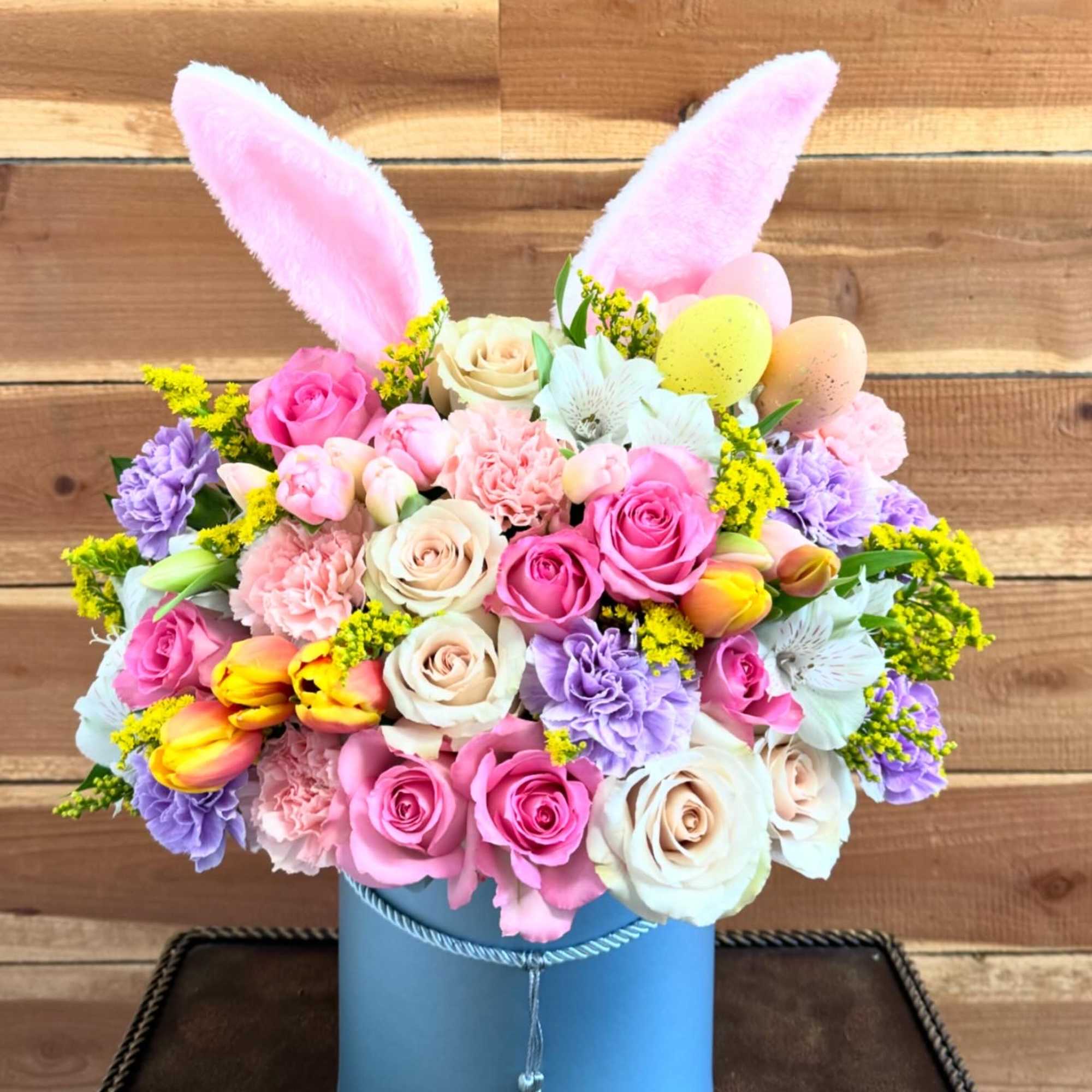 Spring flowers in a hat flower box with bunny ears. 
