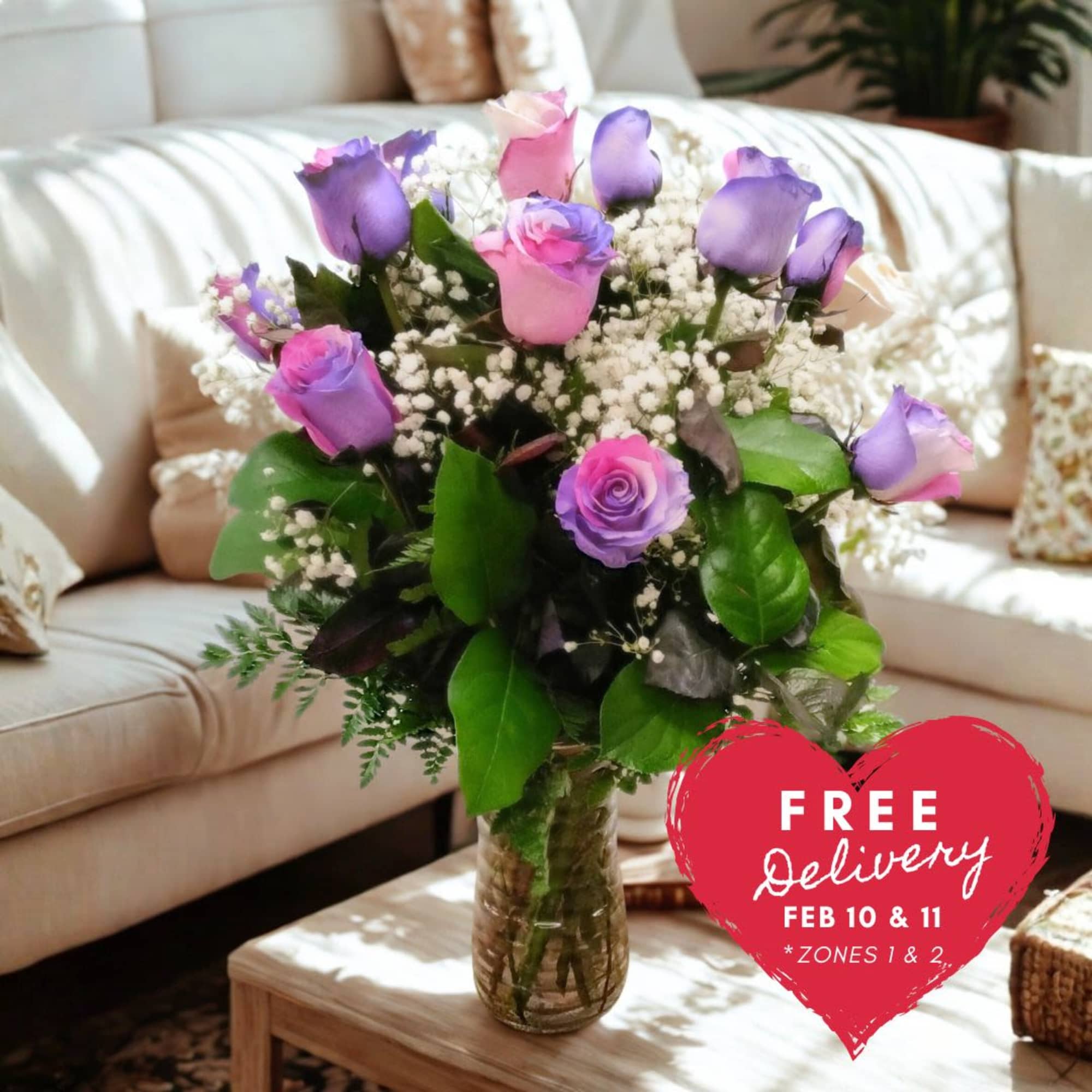 Vase of pink and purple roses with white filler flowers on a coffee table in a living room