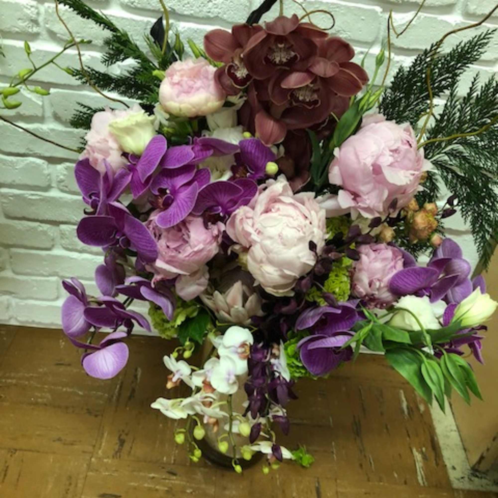 Bouquet of purple orchids and pale pink peonies in a vase