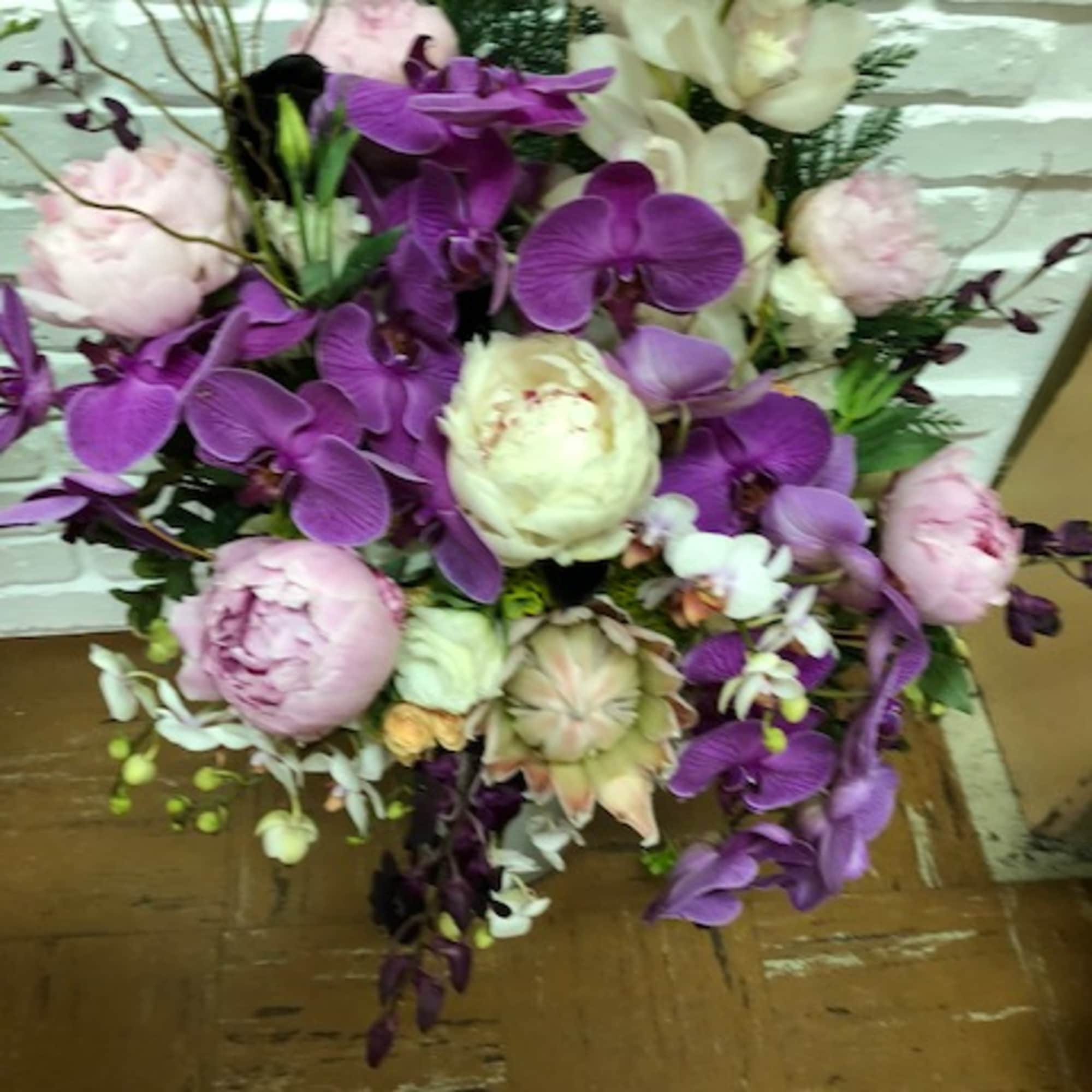 Purple orchids and pale pink peonies in a mixed bouquet