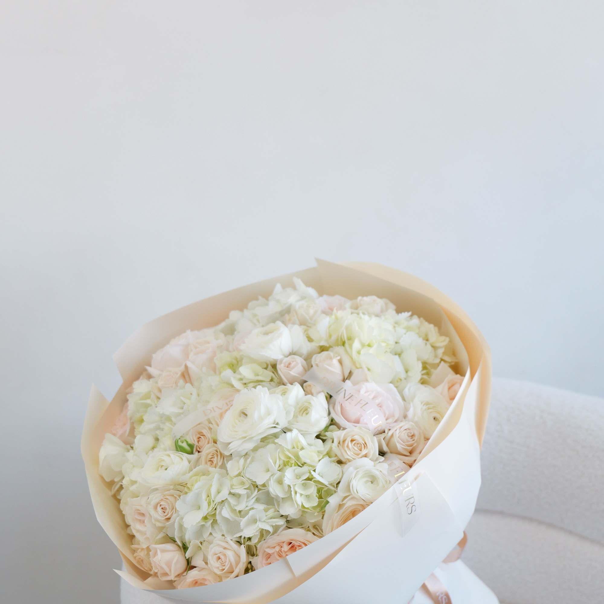 A dreamy bouquet filled with lush ivory blooms and subtle blush accents