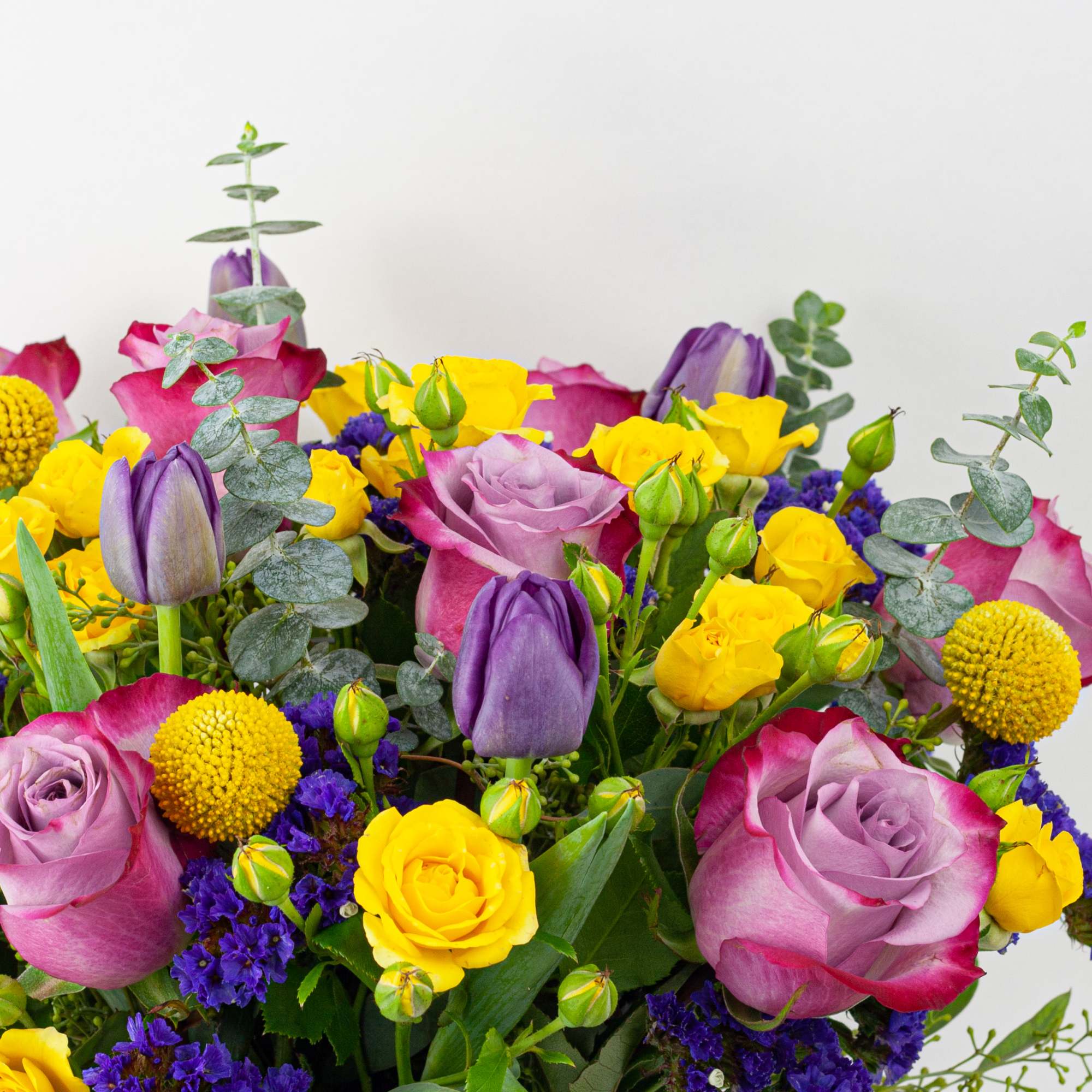 Mixed bouquet of purple and yellow roses with tulips and round yellow blooms