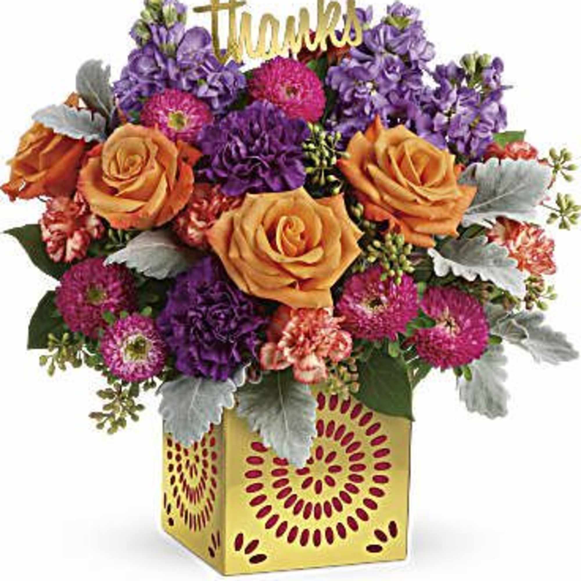 Colorful arrangement of orange roses and purple flowers in a gold cube vase with a thanks sign.