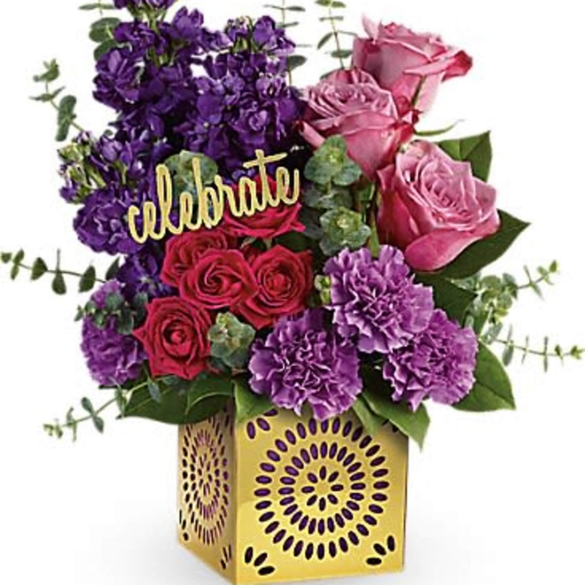 Bright arrangement of pink and red roses with purple flowers in a gold cube vase and a celebrate pick