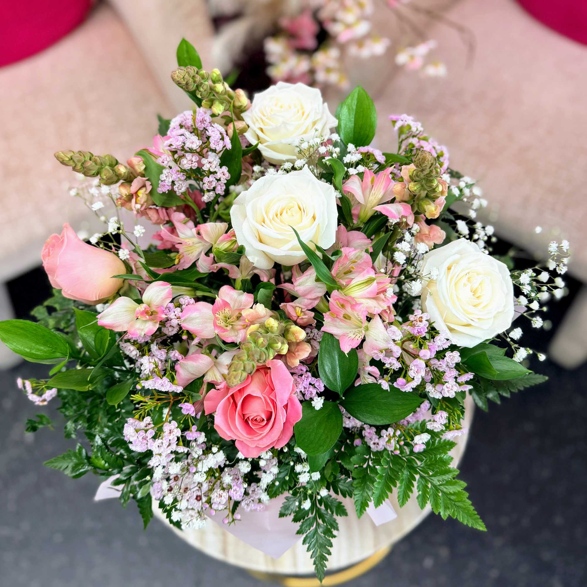 Round bouquet of pink and white roses with mixed pastel flowers in a vase